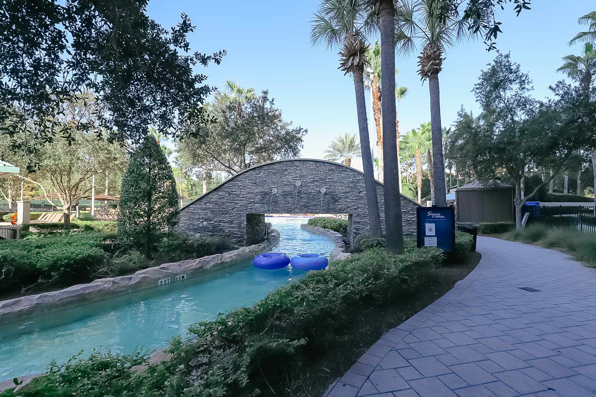 a bridge crossing the lazy river with two tubes 