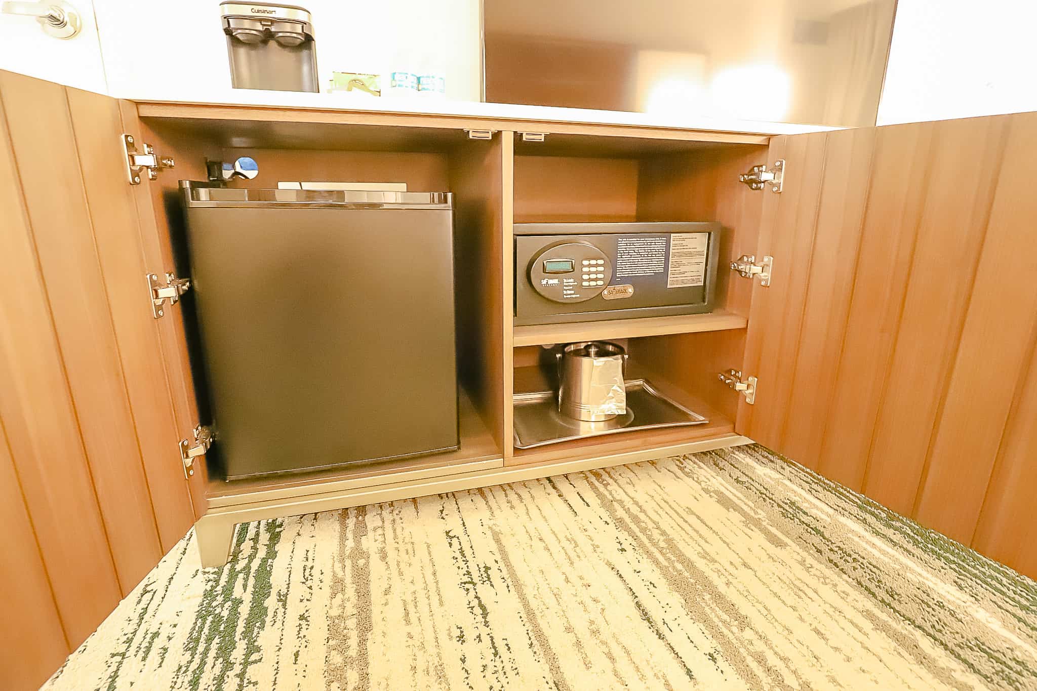 dresser doors open to reveal mini fridge and in-room safe 