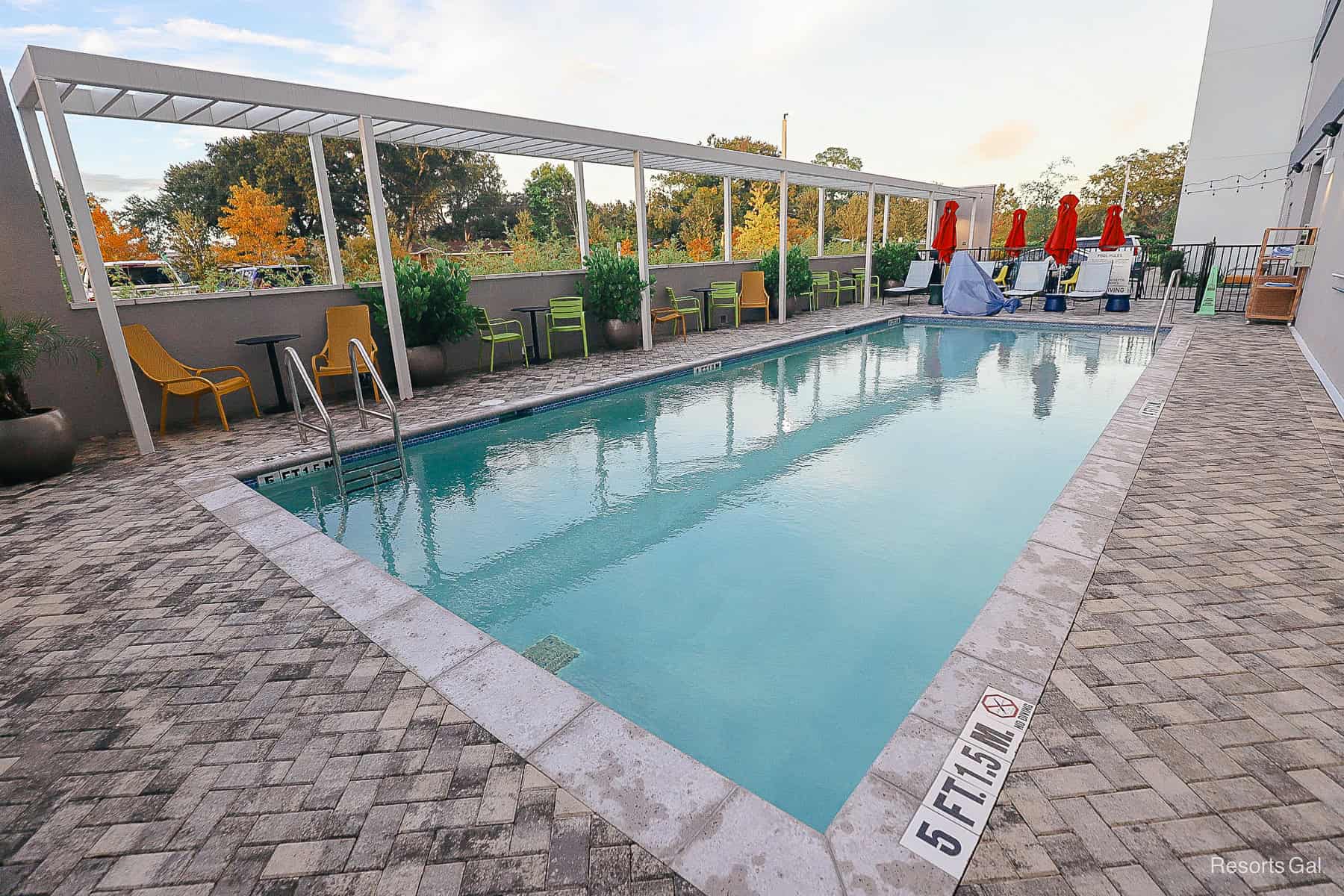 a pool surrounded by outdoor seating 