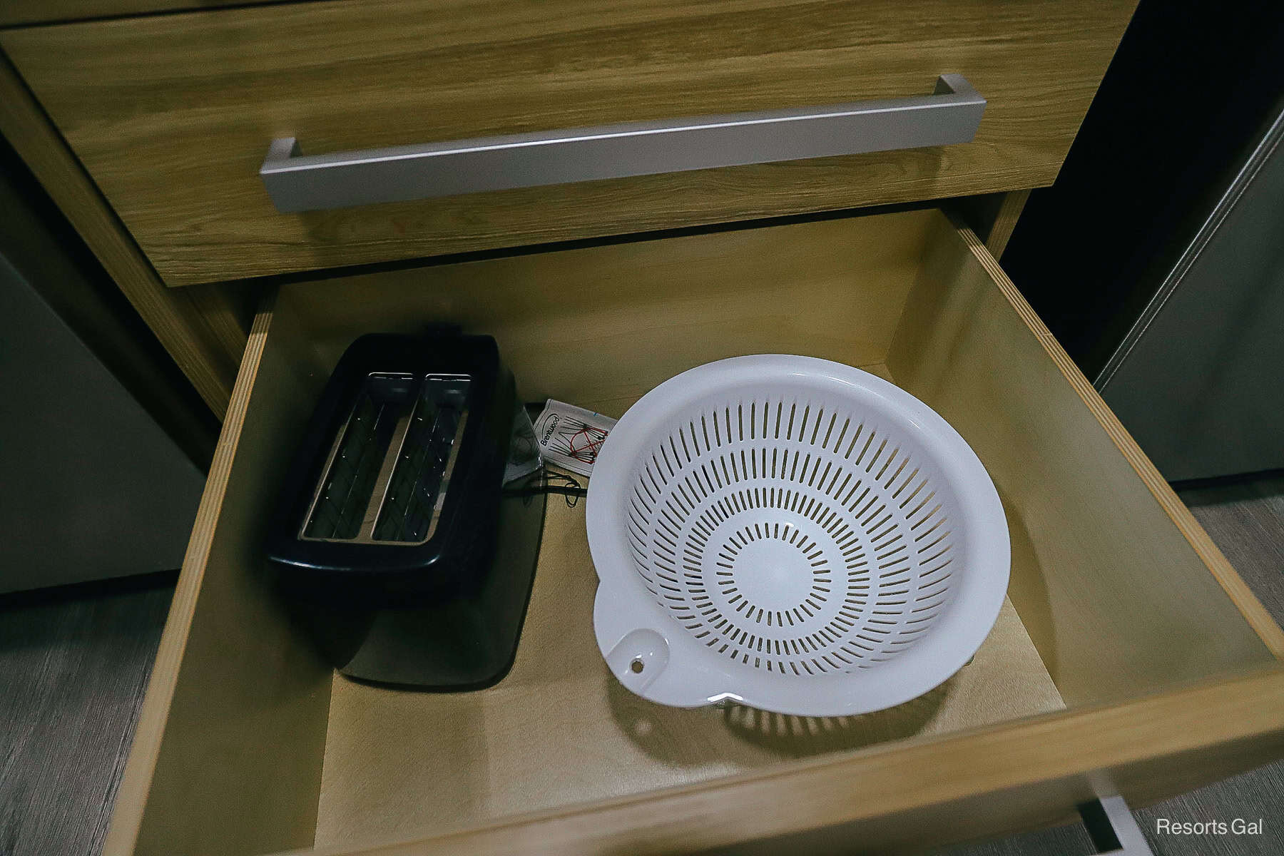 a drawer with a toaster oven and a colander 