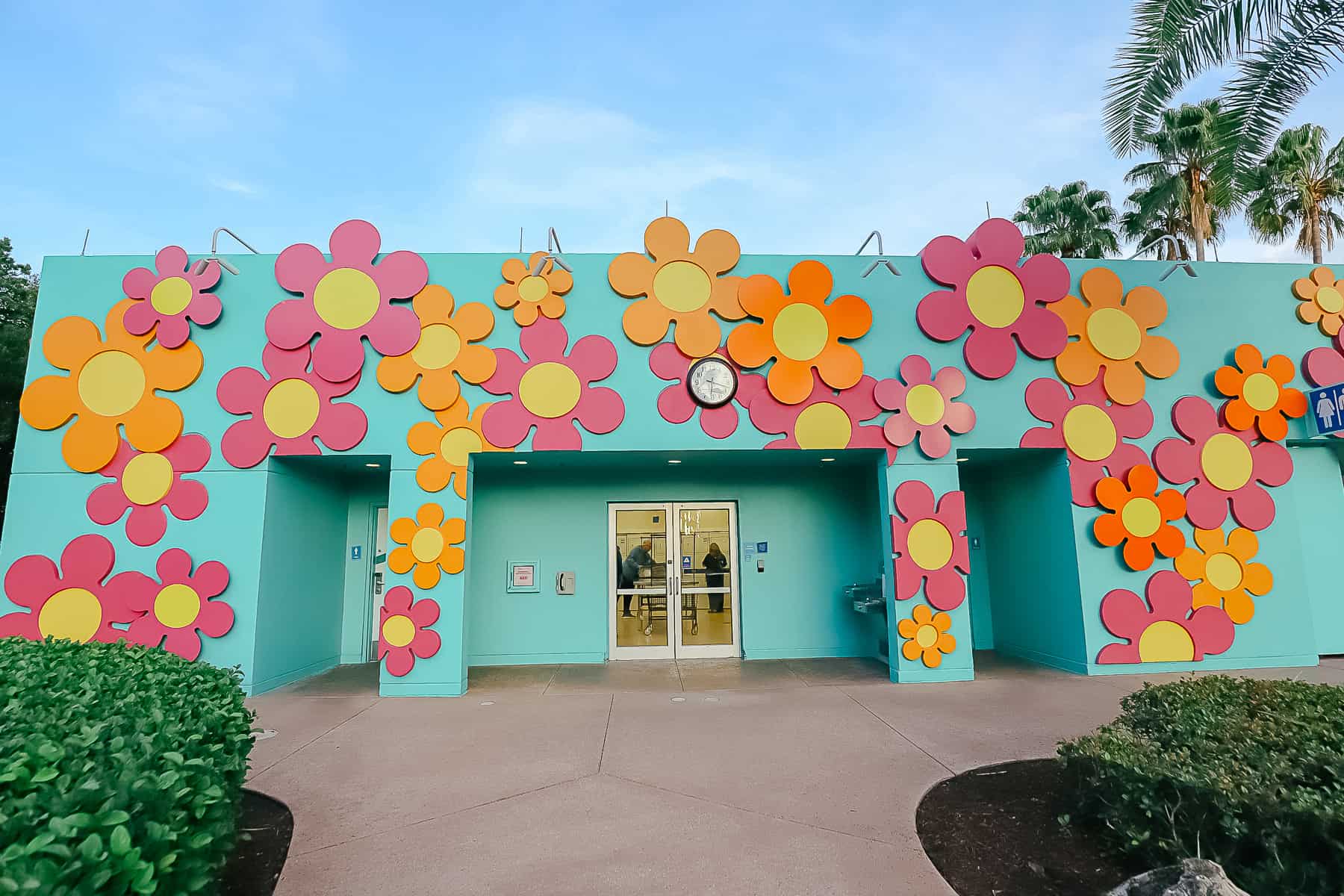 The exterior of the laundry room at Pop Century near the Hippy Dippy Pool is covered in flowers. 