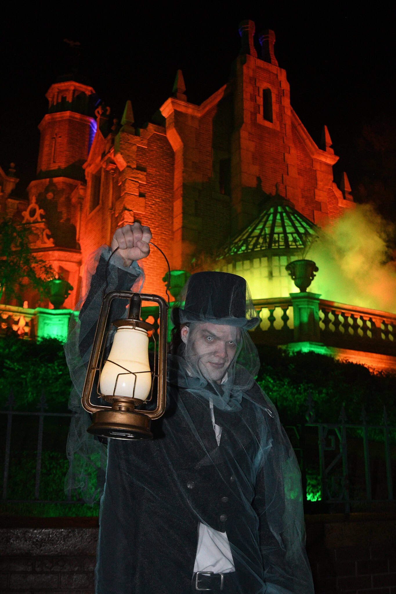 a Haunted Mansion lantern and groundskeeper photo shot 