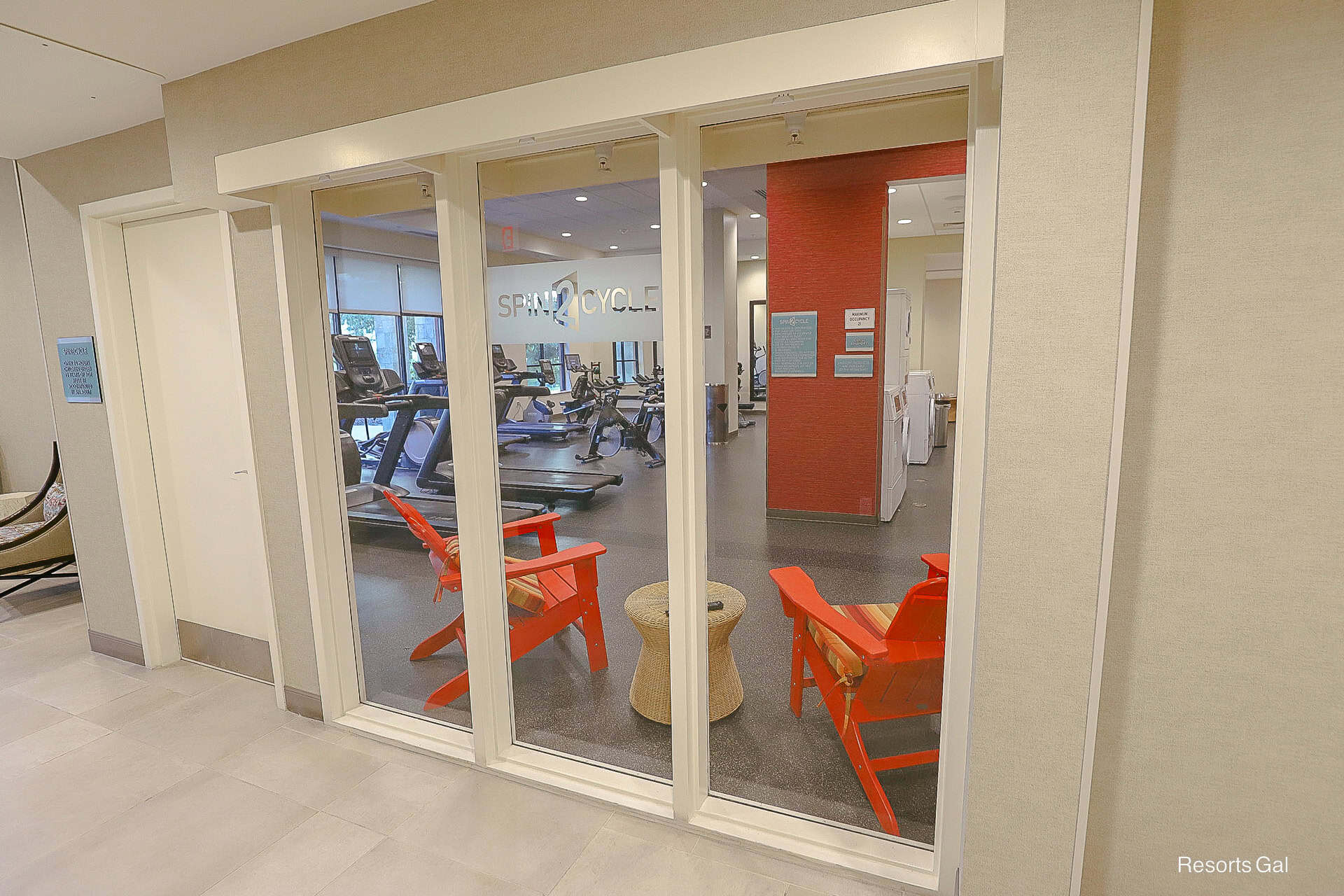 a glass wall that shows how the laundry and exercise rooms are combined at Home2 Suites