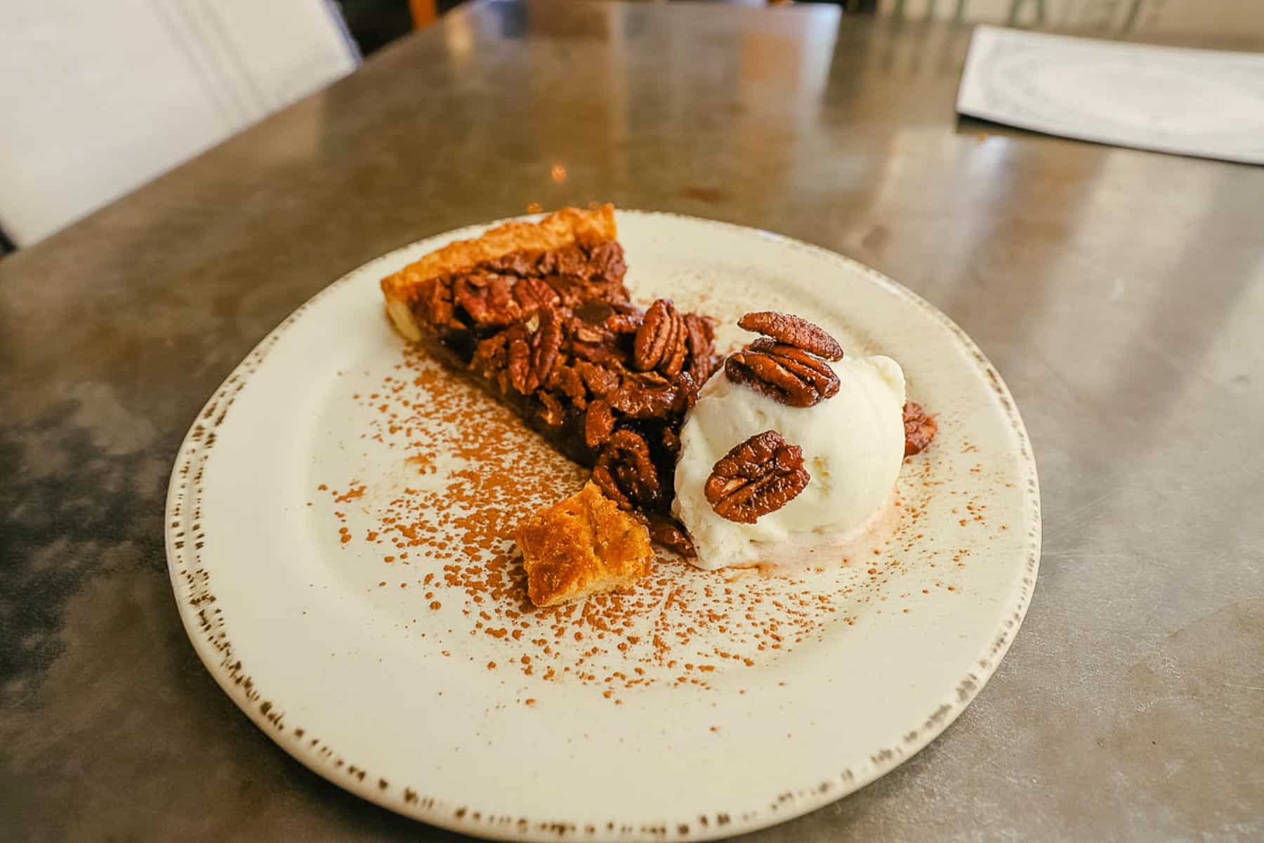 a slice of chocolate pecan pie with a scoop of ice cream 