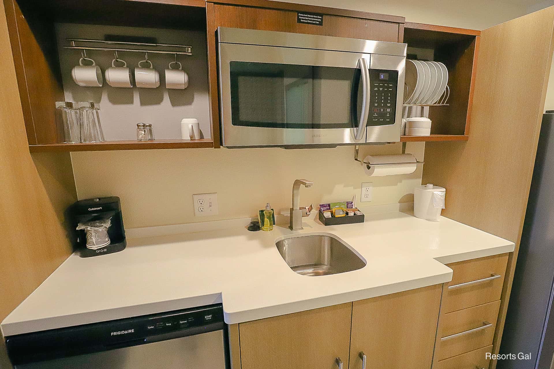 a closeup of the appliances: microwave, coffee maker, sink, and dishwasher
