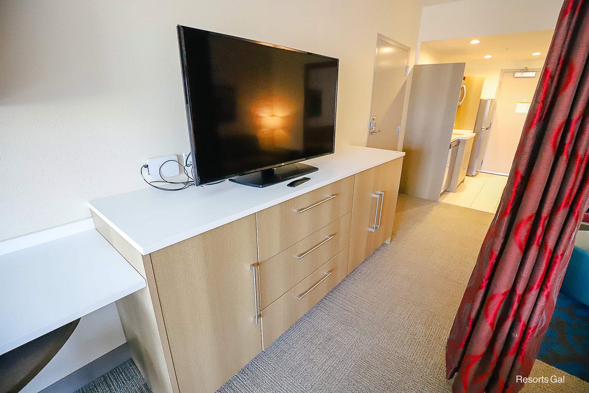 a flat screen television sitting on top of a dresser