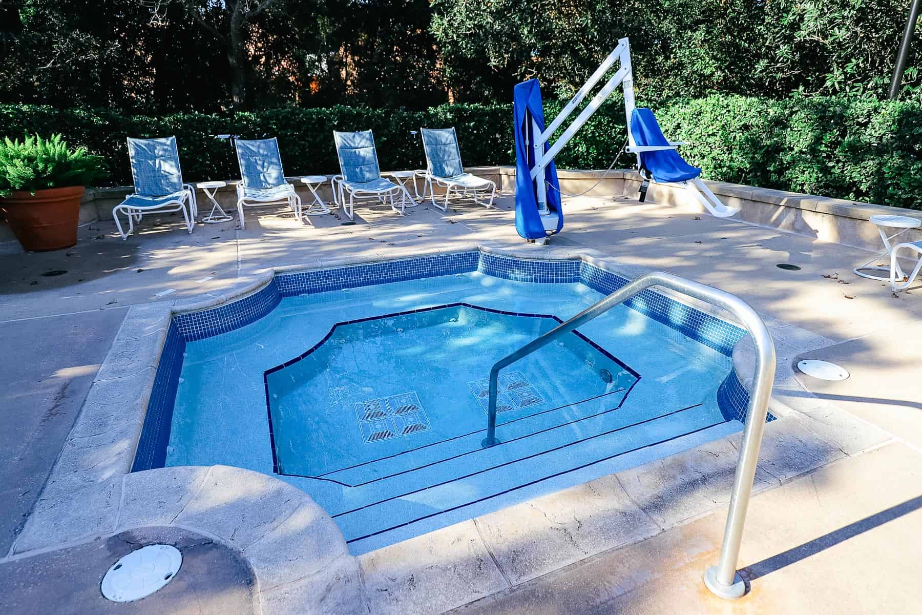 a hot tub at Disney's Yacht Club with a mobility lift and four lounge chairs 