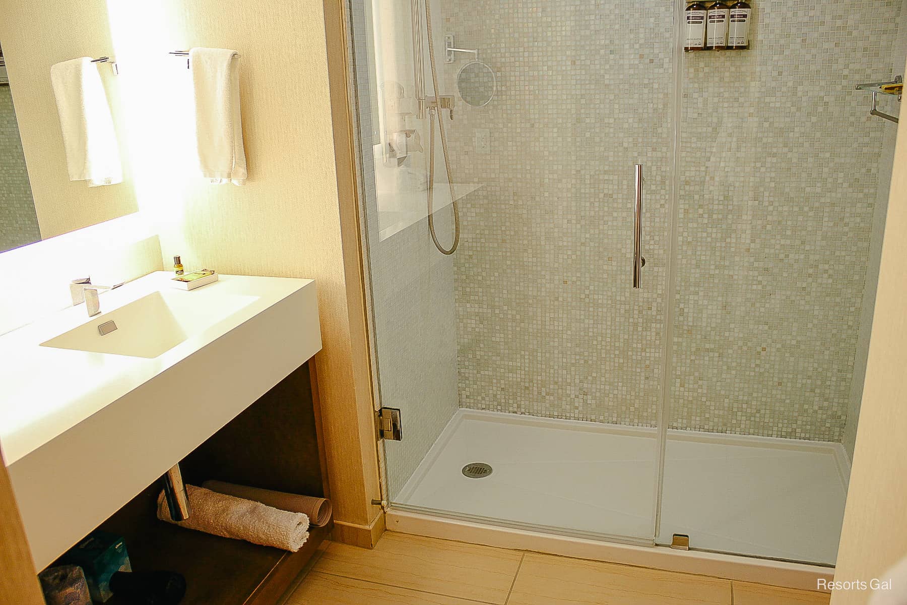 walk-in shower with glass door and mosaic tile design 