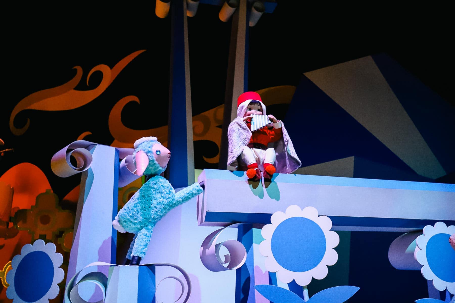 "it's a small world" scene with lamb and a doll playing an instrument. 