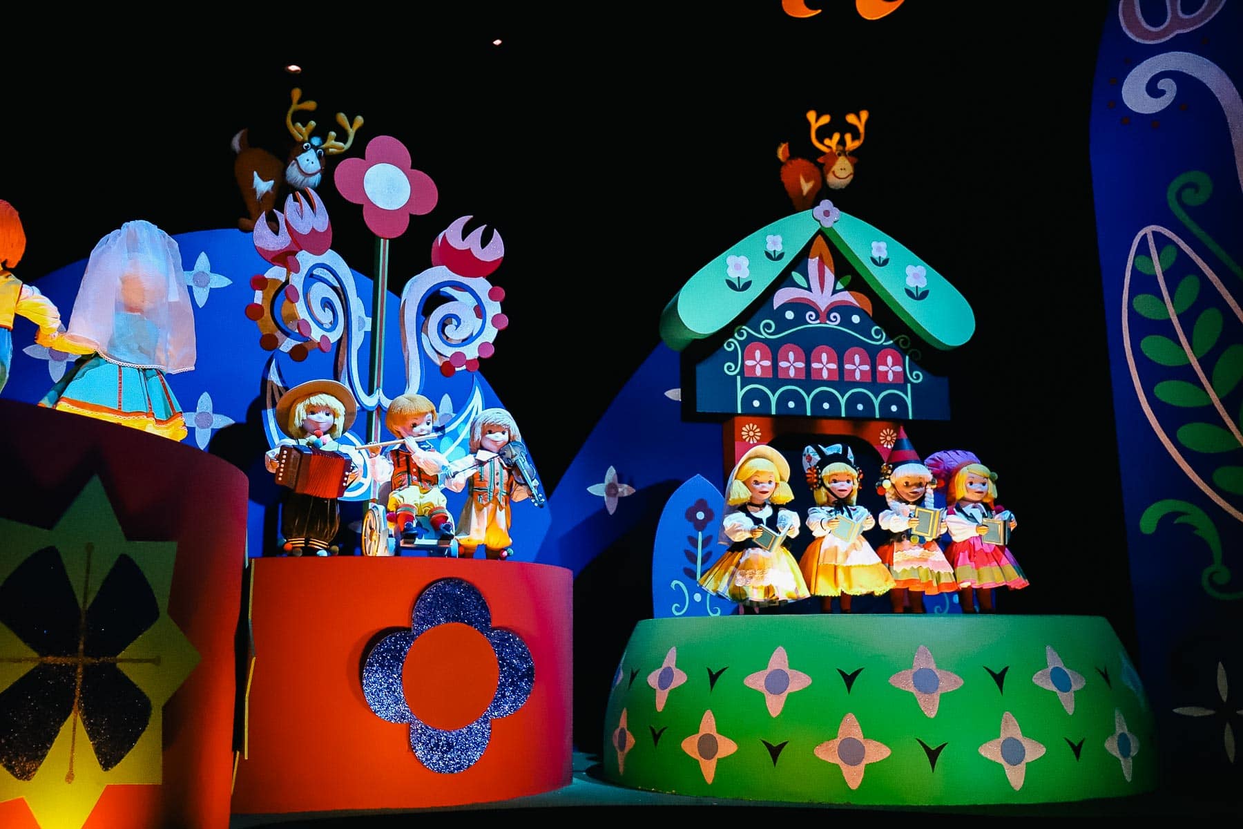 The first set of dolls at the ride's entrance include a new doll who's in a wheelchair. He is playing a flute. 