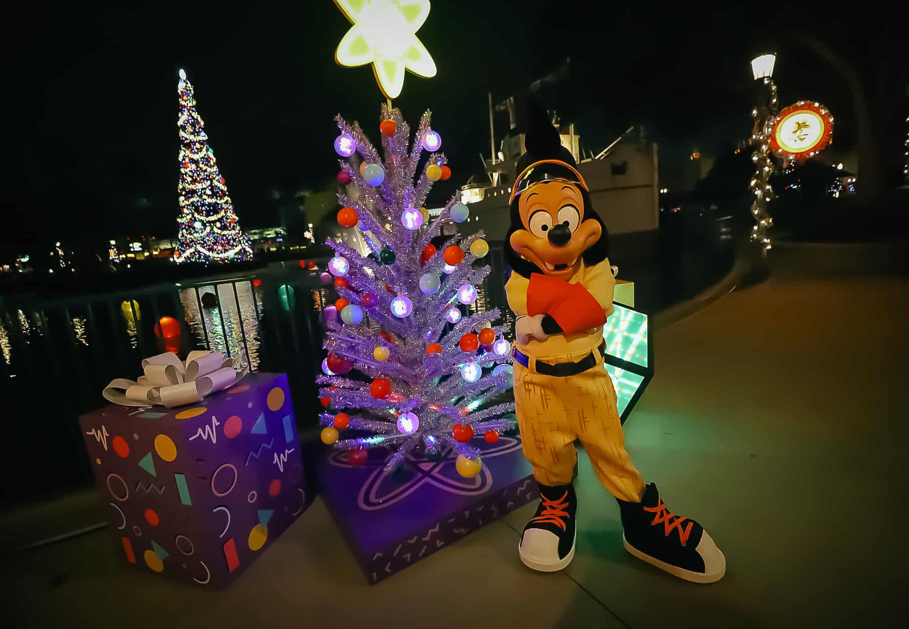Max poses in his Powerline suit in front of a tinsel tree and large purple wrapped presents at Echo Lake. 