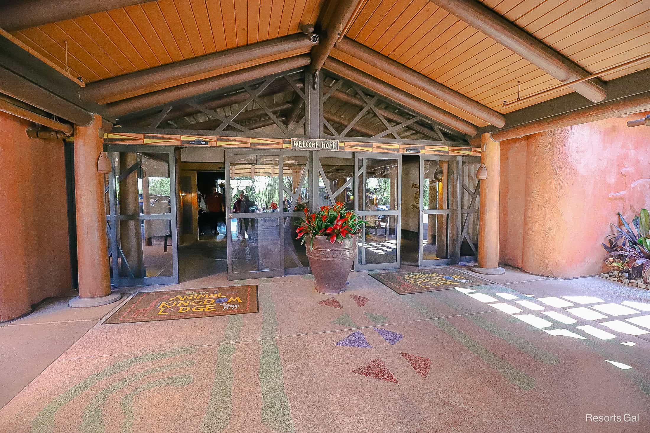 the entrance to Kidani Village with a sign that says Welcome Home and two Animal Kingdom Lodge door mats 