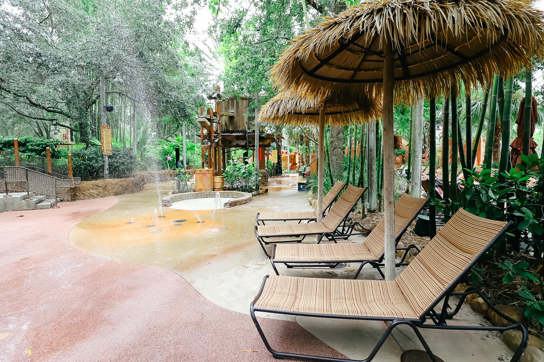 lounge chairs with thatch umbrellas around the aquatic play area 