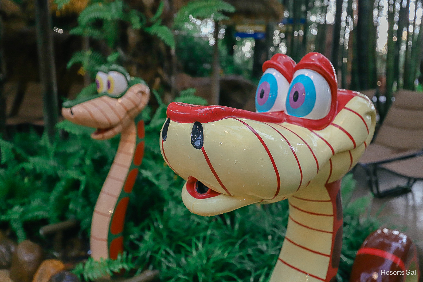 two snake statues with stripes and big eyes spit water 
