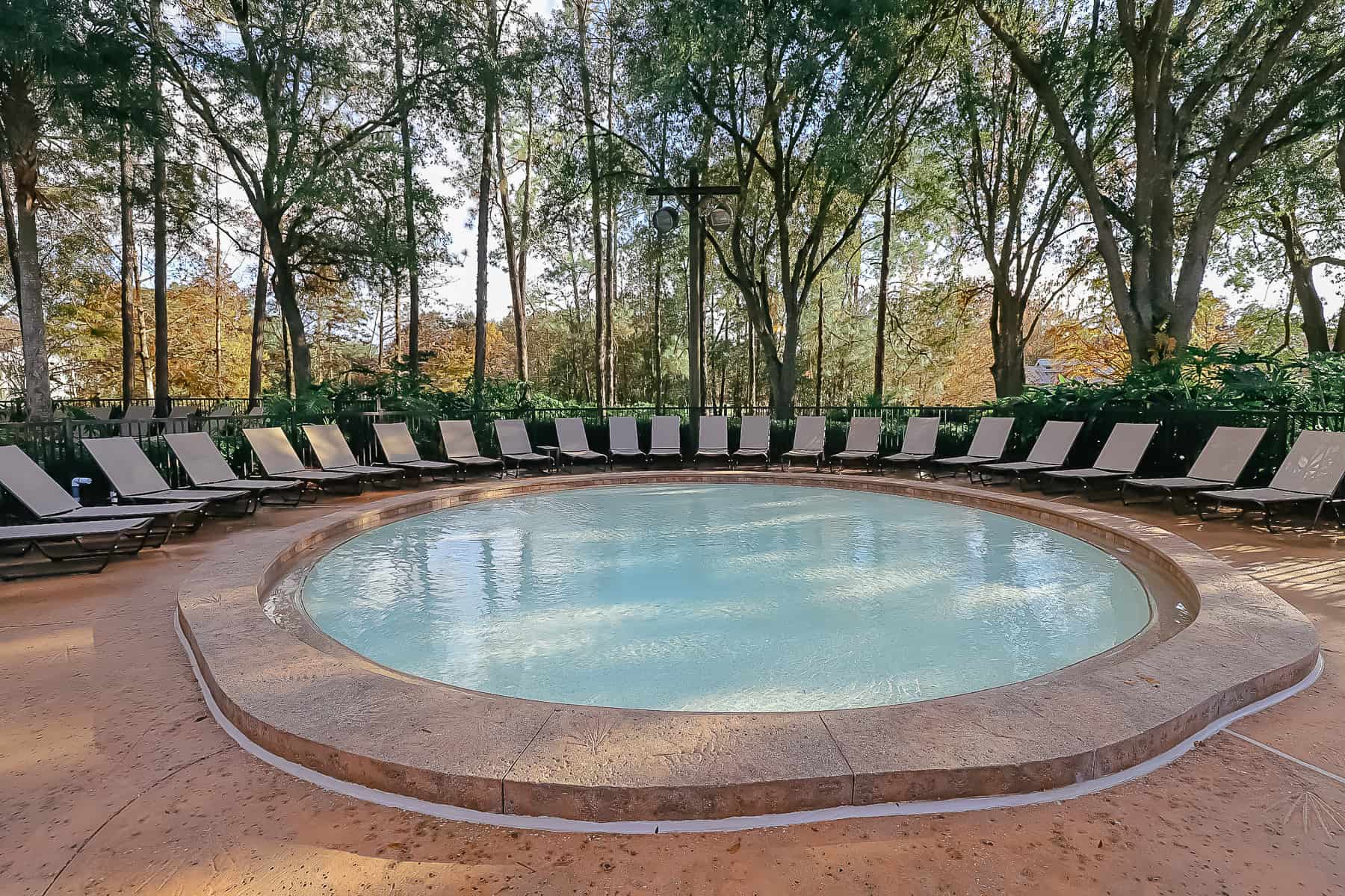 a kiddie pool with lounge chairs surrounding it 