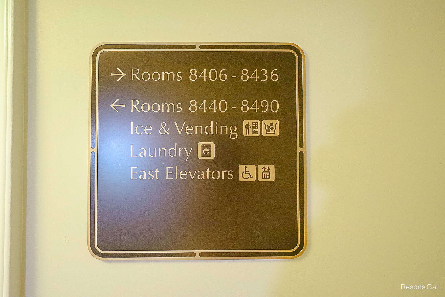 a sign with directionals for room numbers and the laundry room at Disney's Riviera 