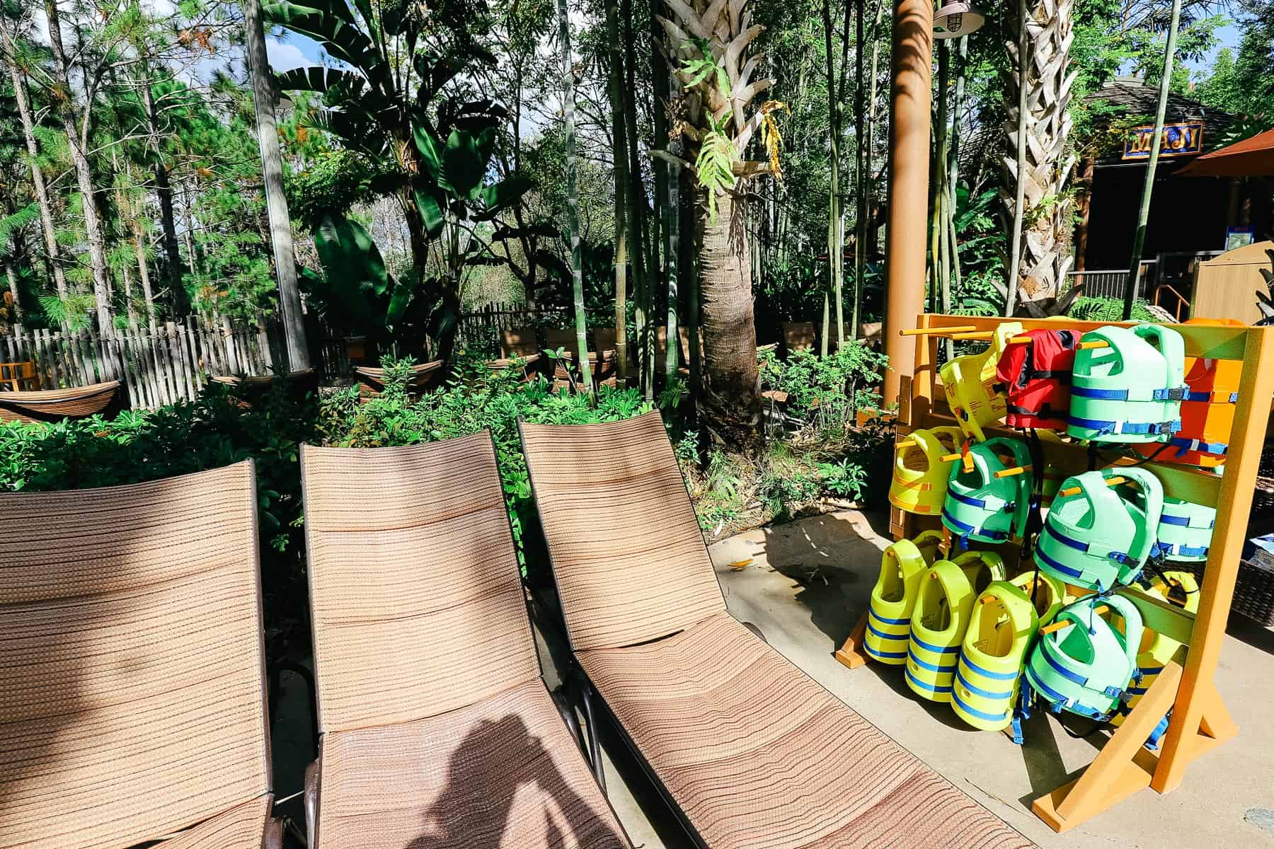 a stand with life jackets in green, orange, and yellow 