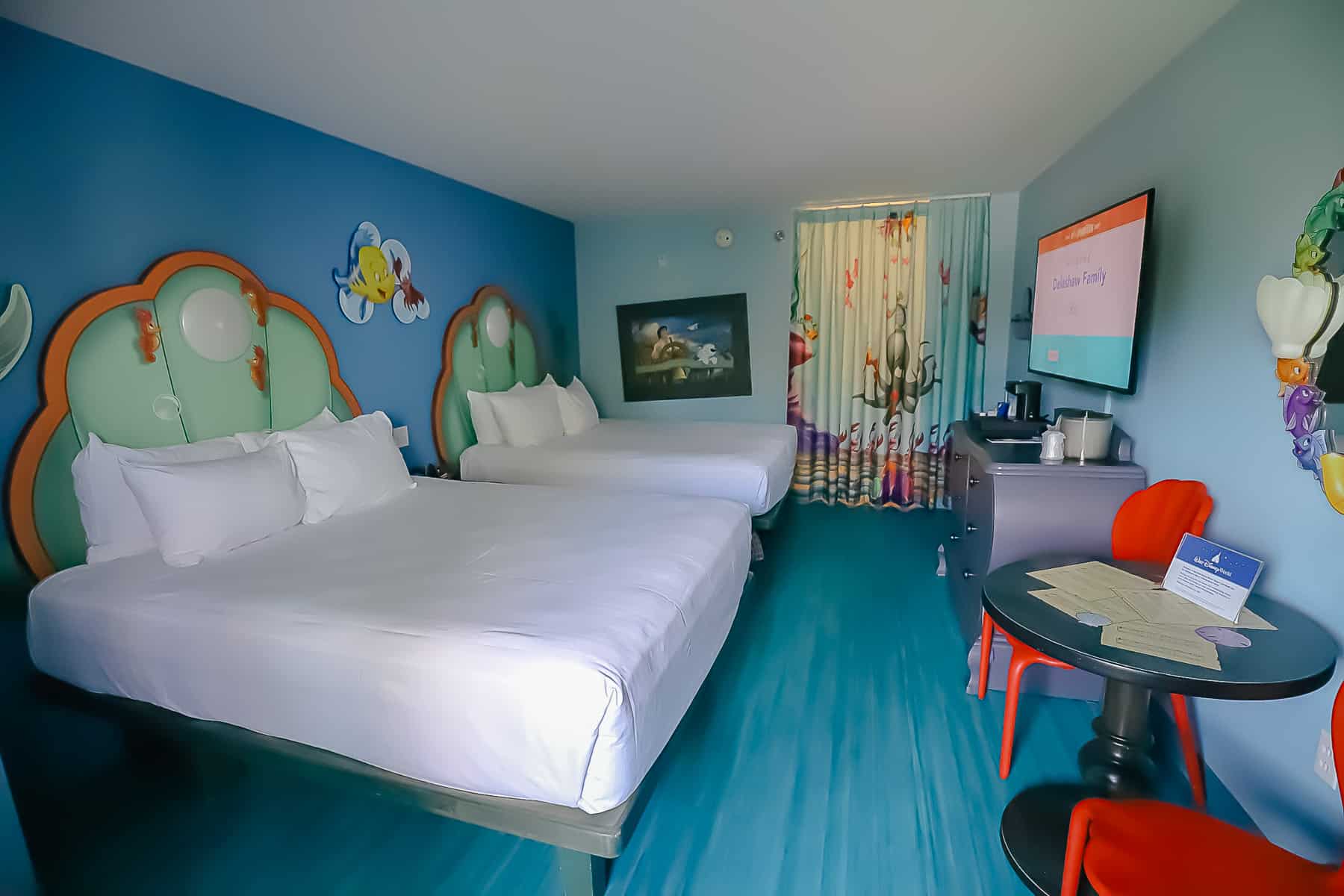 Shows the standard guest room at Art of Animation with curtains closed to the bath area. 