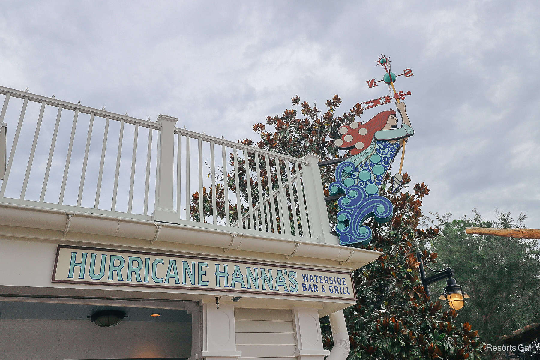 a sign with a mermaid holding a compass that says Hurricane Hanna's Waterside Bar and Grill 