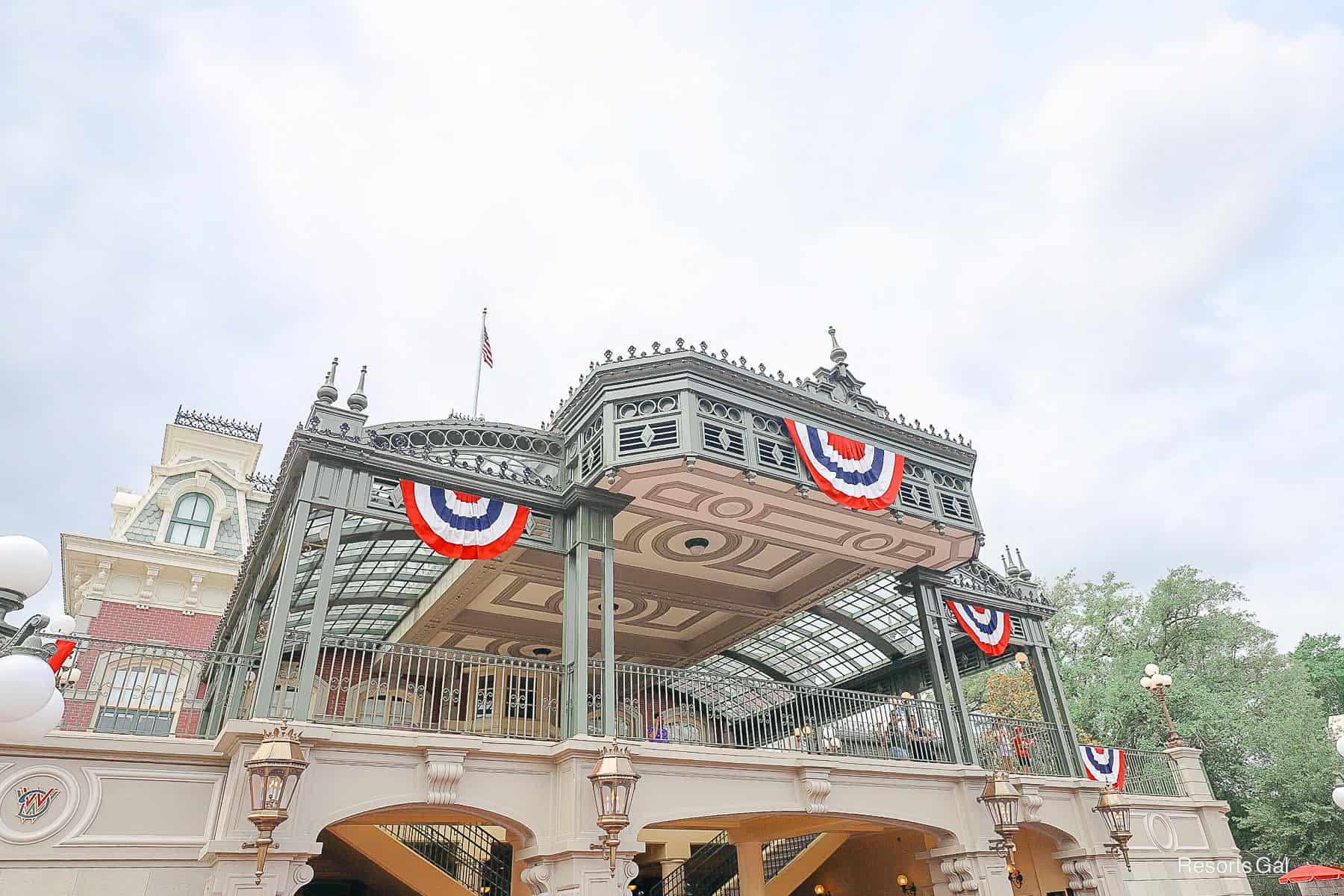 red, white, and blue bunting decorates the train station at Magic Kingdom 