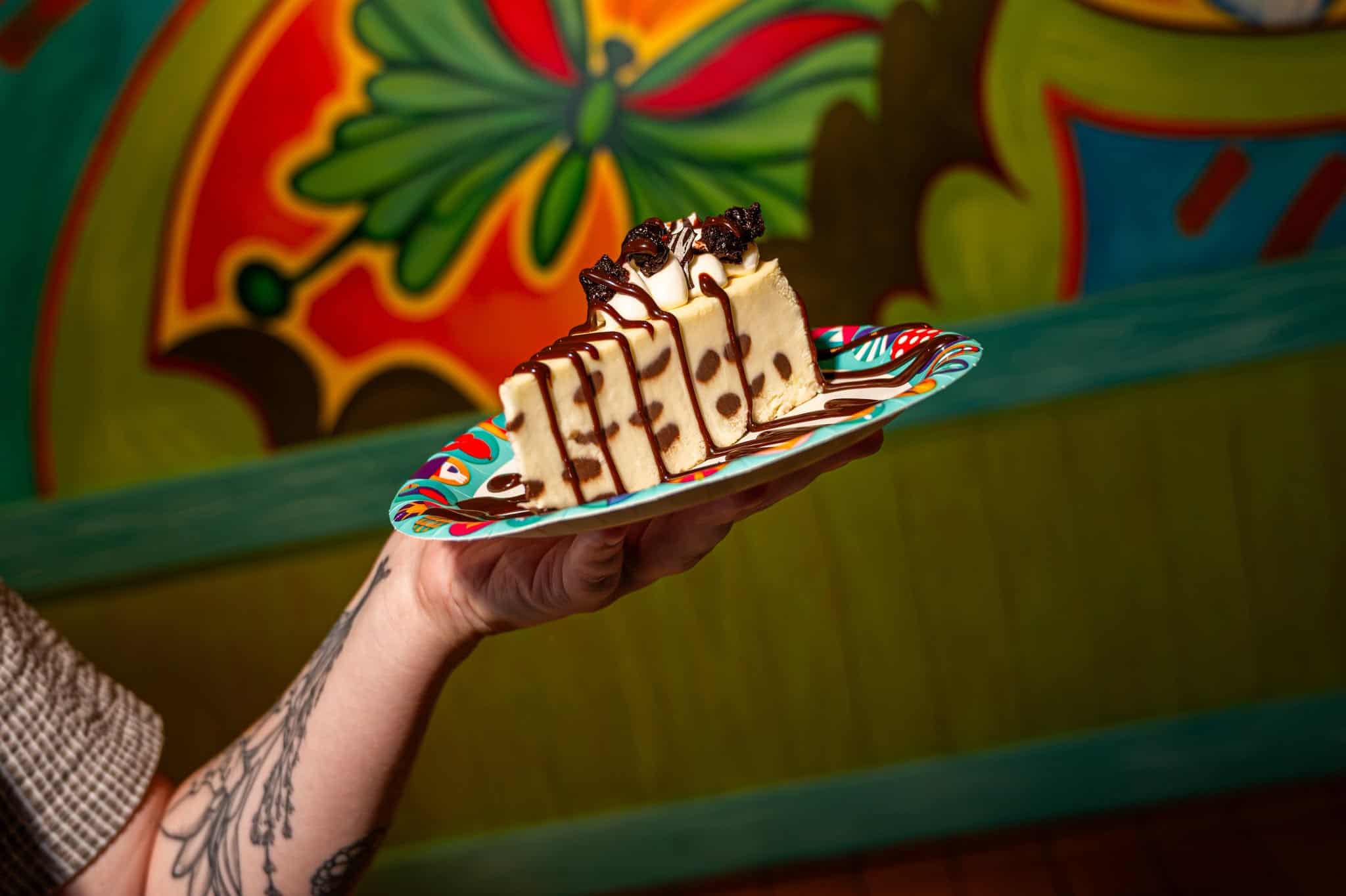 a hand holding a marble cheesecake with chocolate swirls