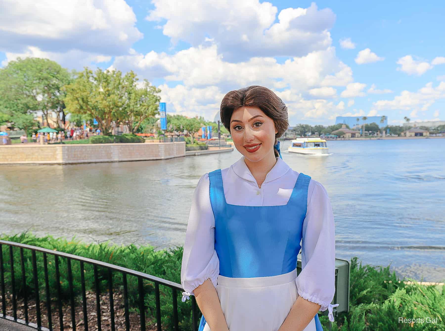 Belle wearing a blue dress with white pinafore apron. 