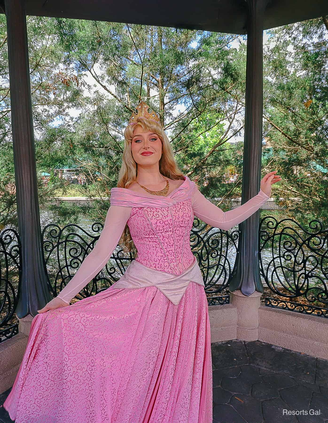 Princess Aurora poses with her arms out in a royal look. 
