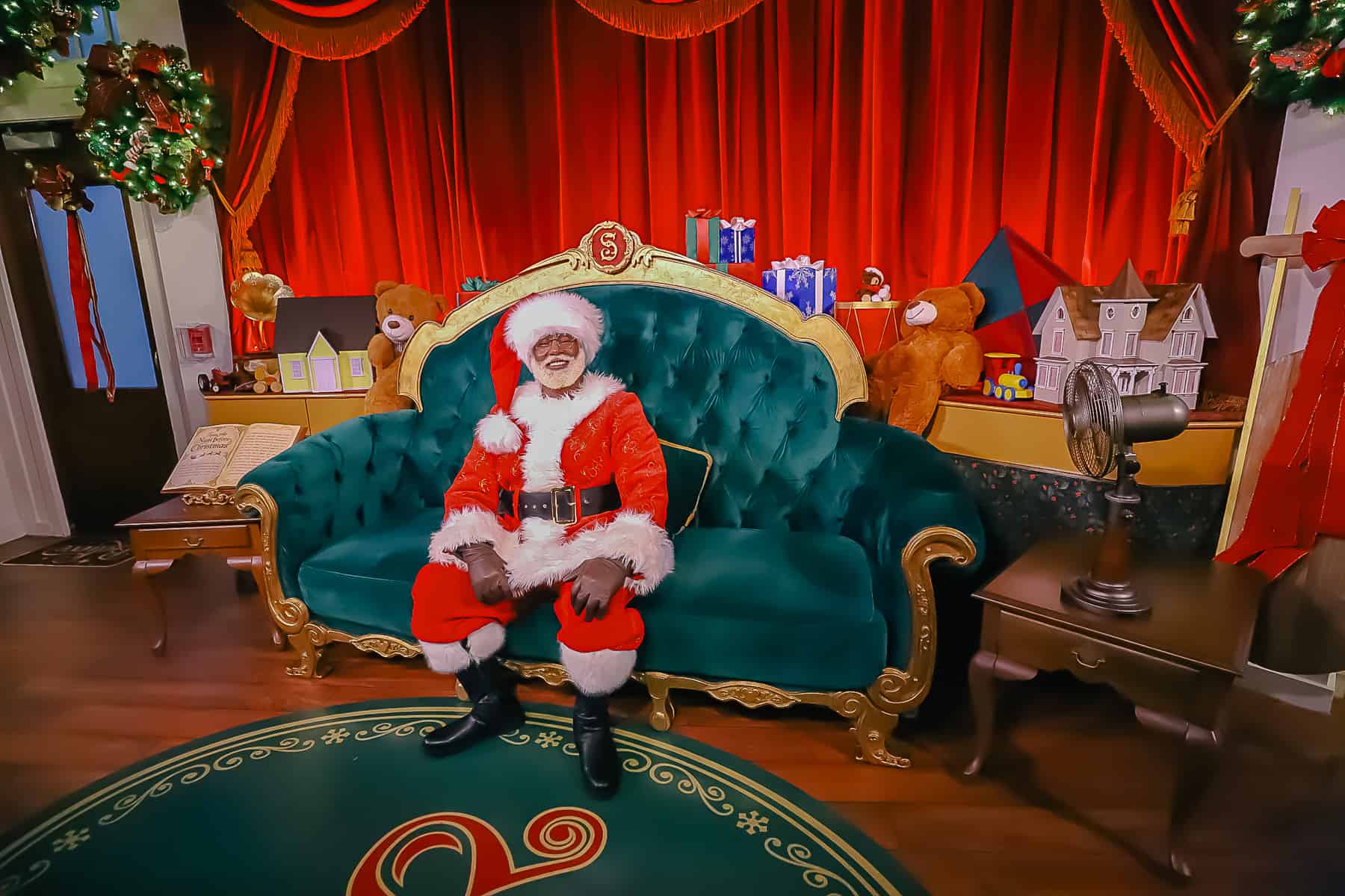 Santa Claus sitting on a green velvet couch. 