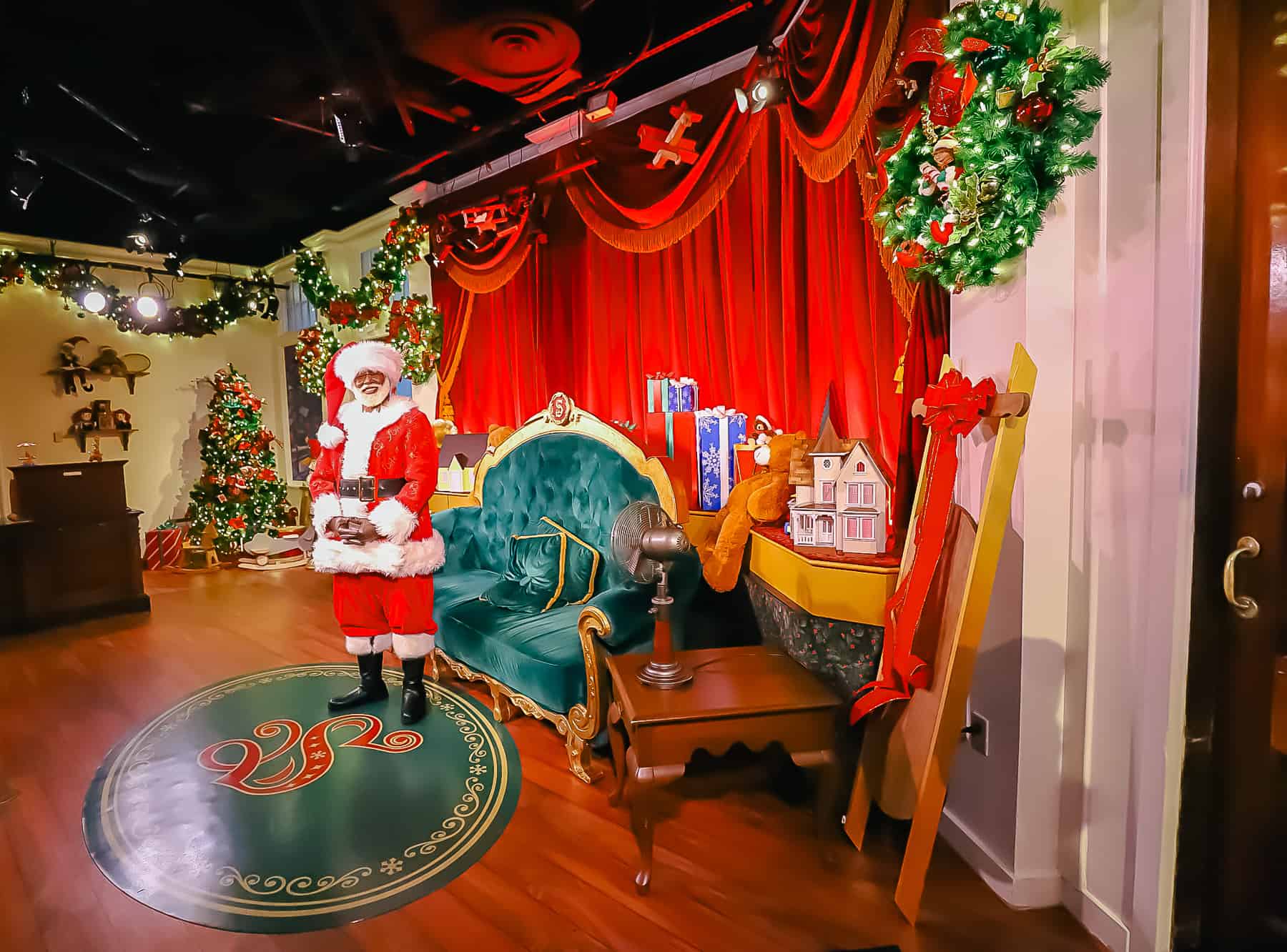 Inside the Christmas shop where Santa is standing waiting.