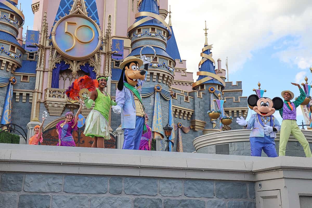 Tiana, Goofy, and Mickey Mouse join the stage. 
