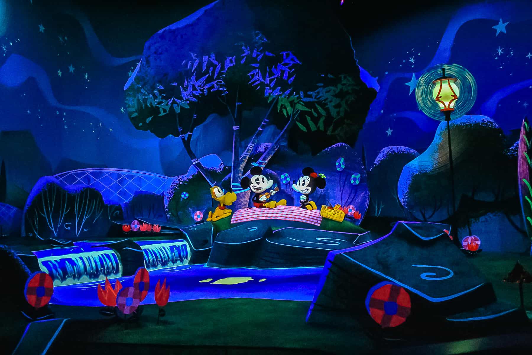 Mickey and Minnie are enjoying a picnic with Pluto. 