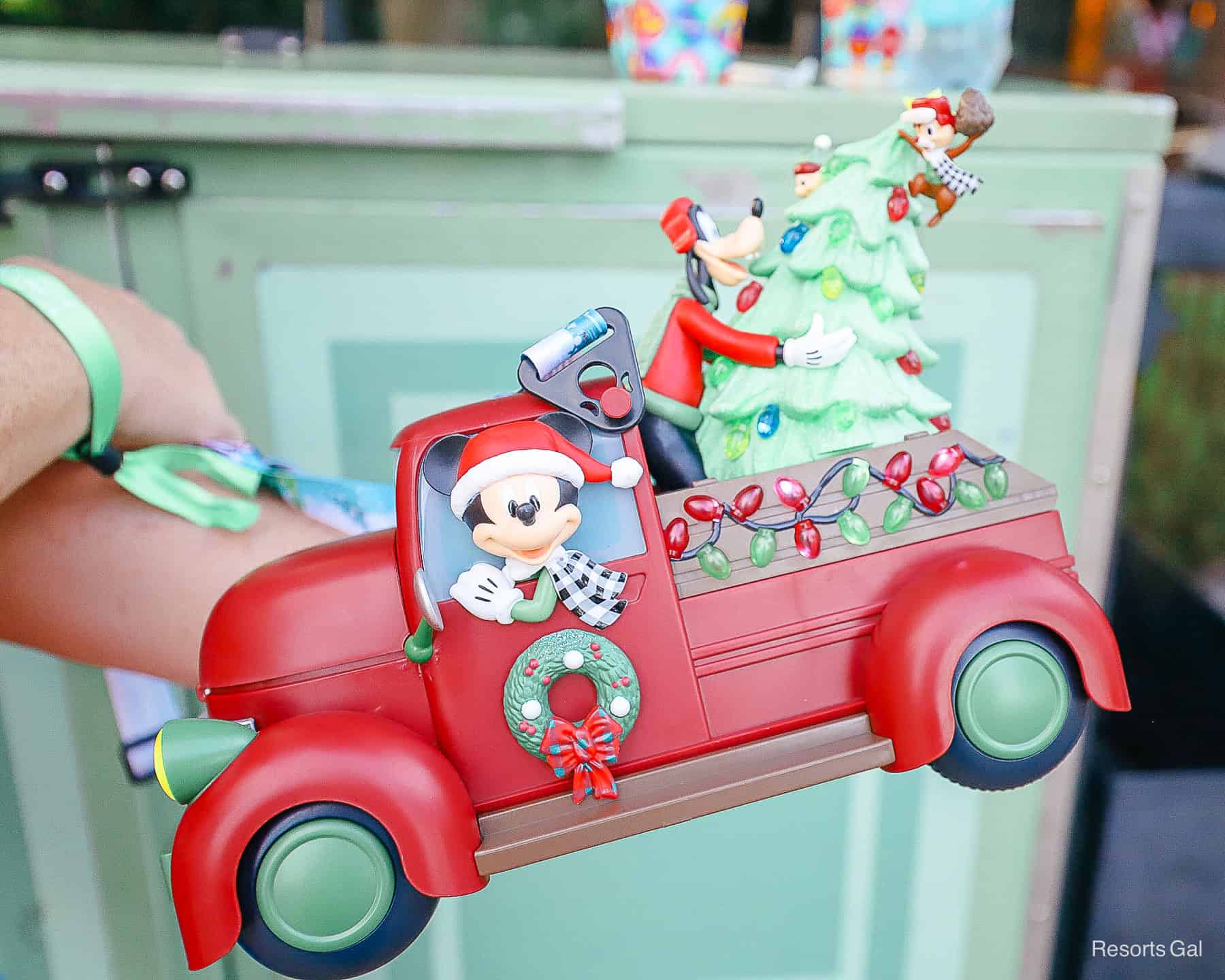 someone holding the popcorn bucket so you can see Mickey and the wheel, Goofy in the back and Chip and Dale on the tree 