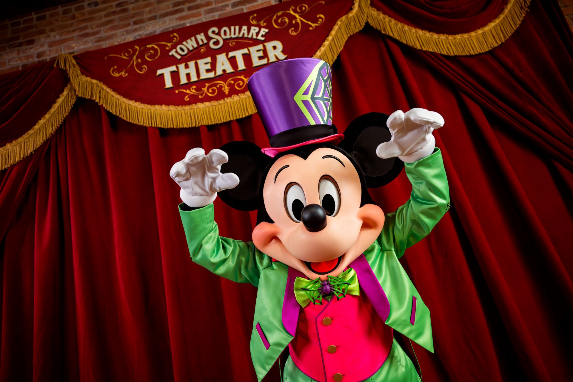 Mickey in his lime green Halloween costume with monster hands pose 