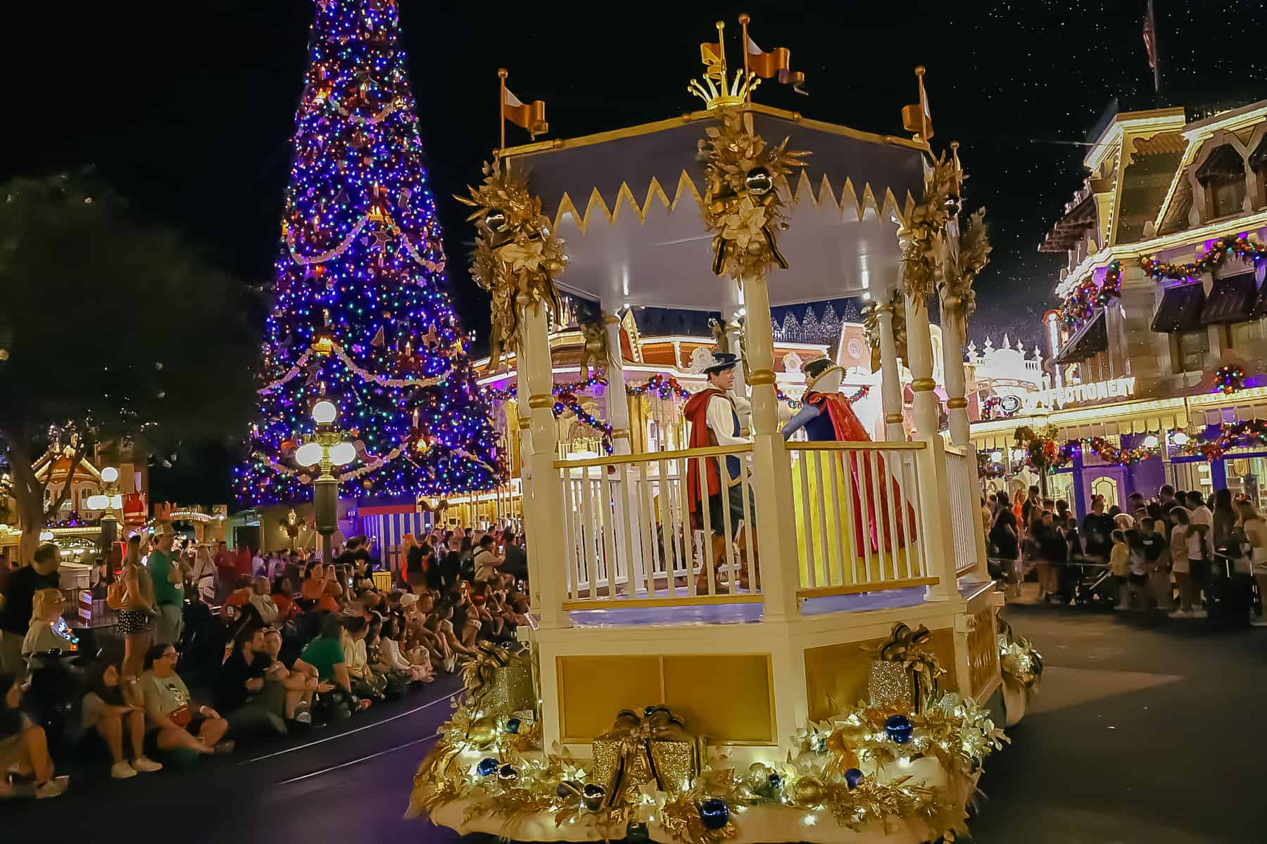 Snow White and The Prince ride in a gazebo float. 