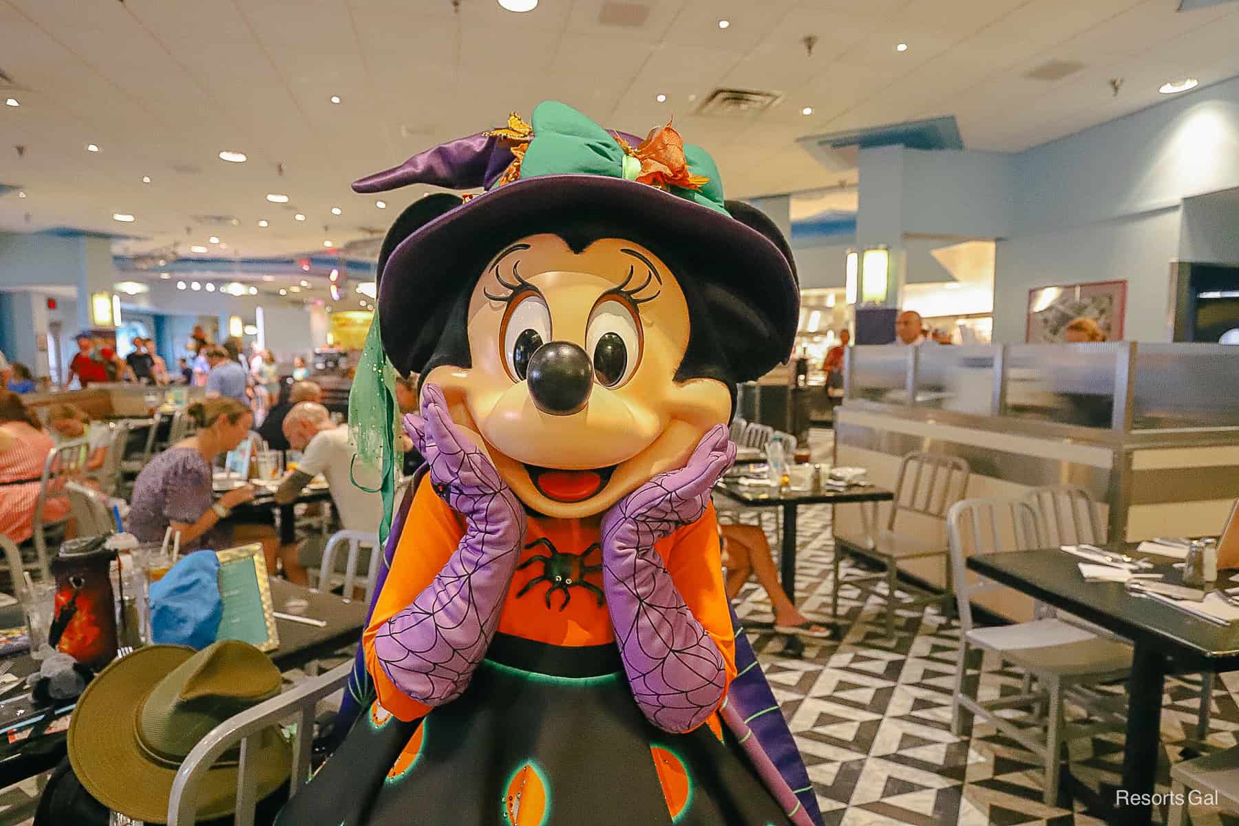 Minnie Mouse poses wearing purple gloves with hands on cheeks at Minnie's Halloween Dine 