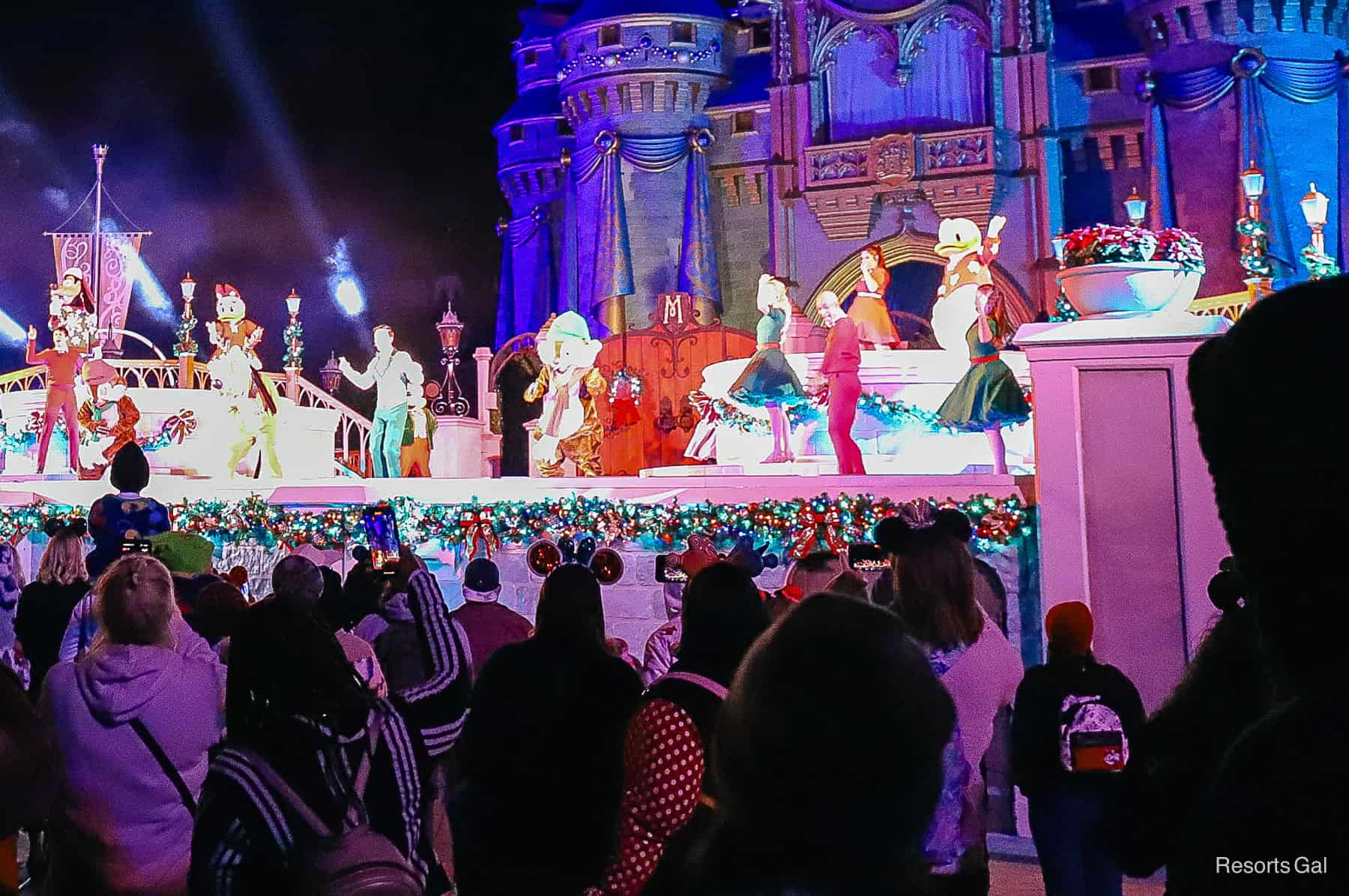 a host of characters on stage with dancers during the Mickey's Most Merriest Celebration stage show