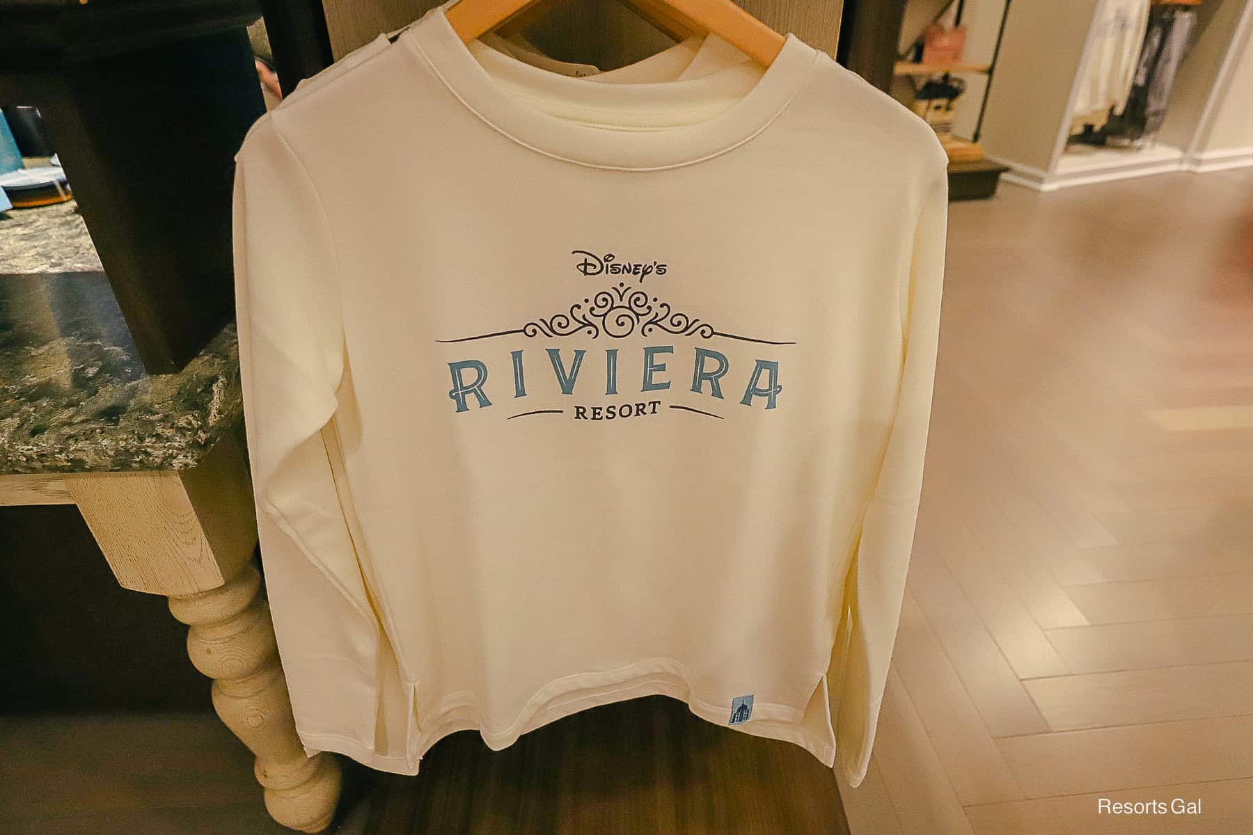 a white sweatshirt with the Riviera Resort logo in blue