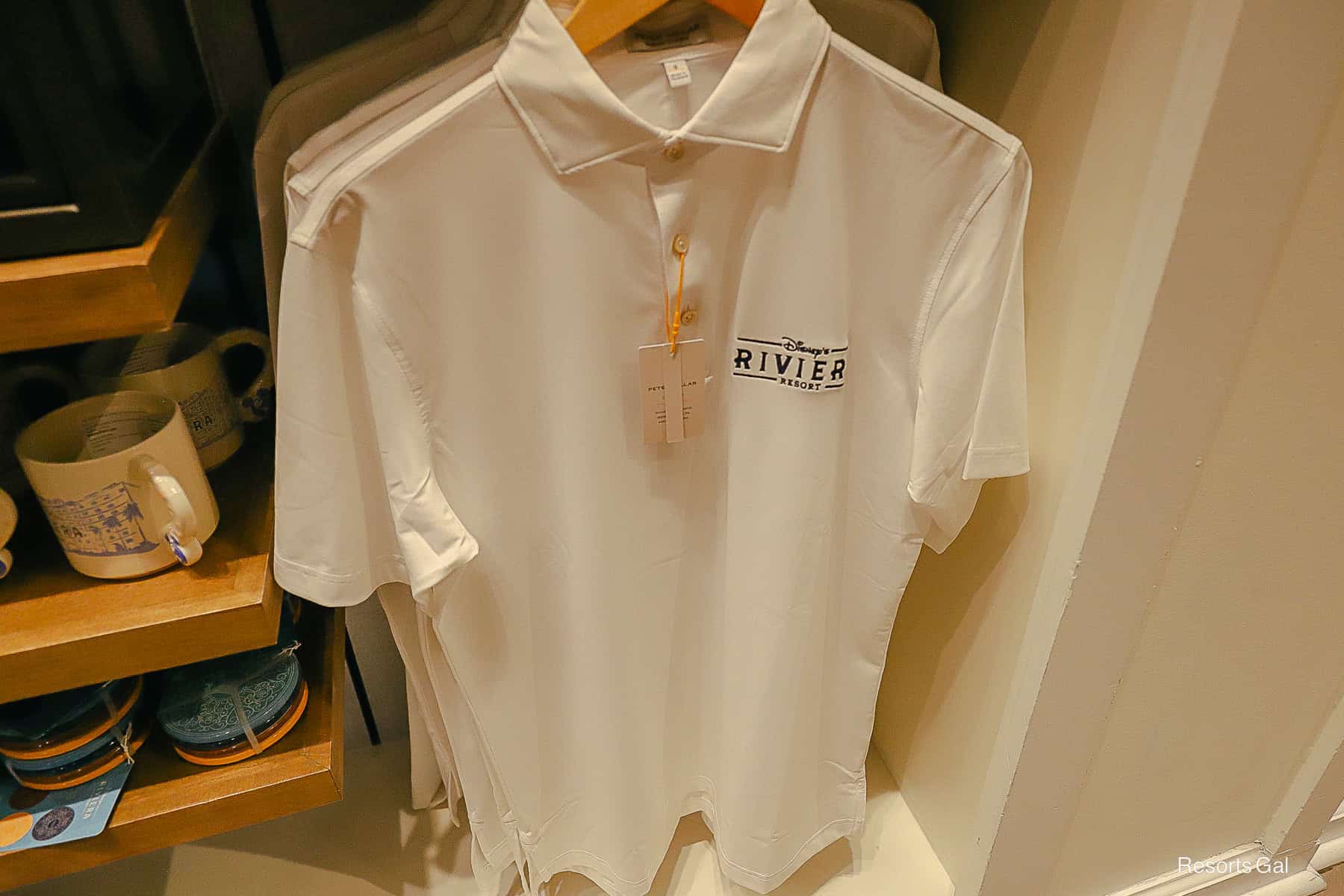 a white Peter Millar polo shirt with the Riviera Resort logo