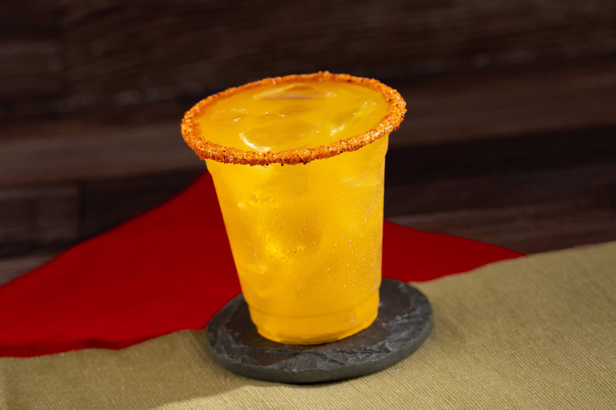 an orange colored drink with a red rim