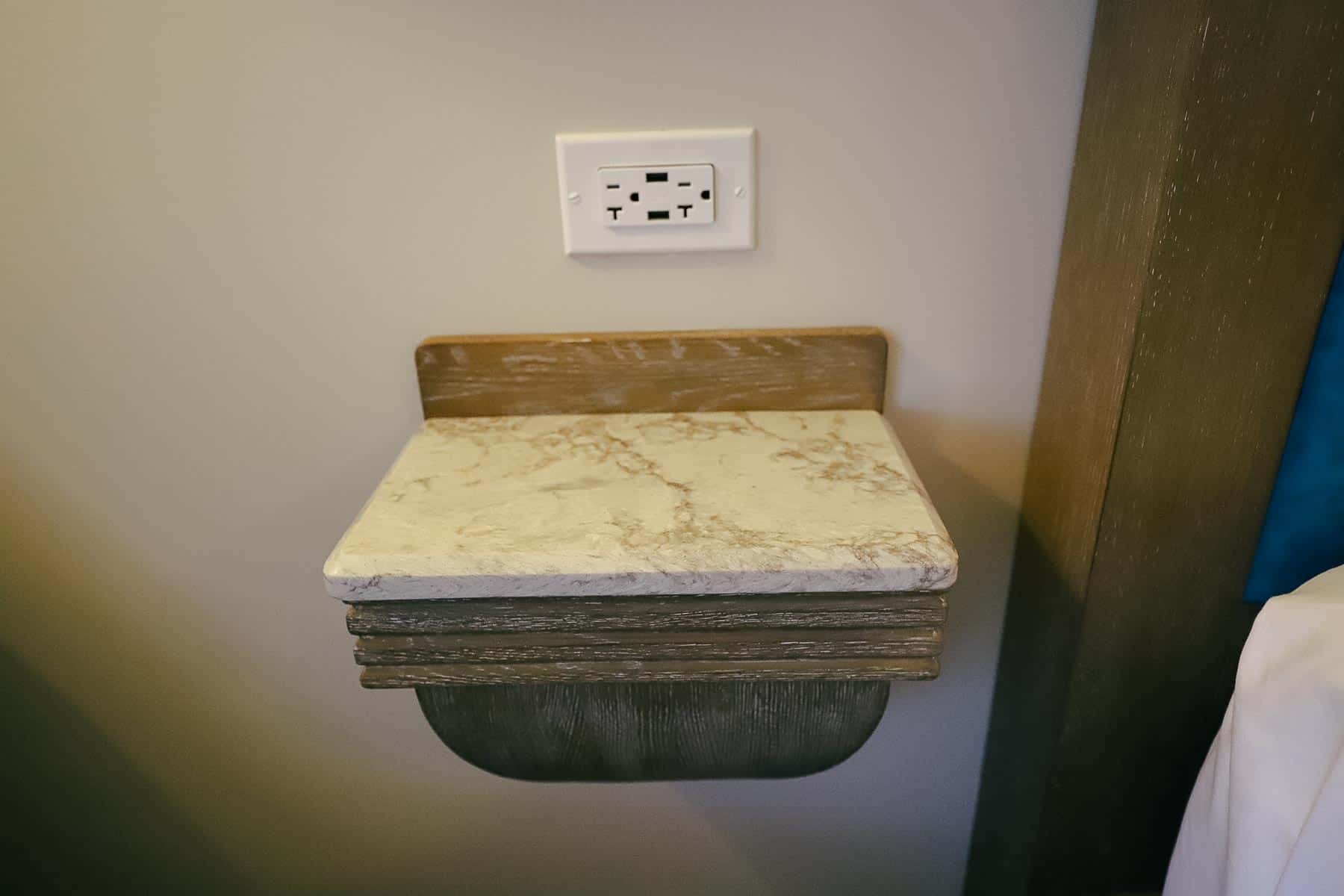 A small stand provides a place to lay your phone with chargers above it. 