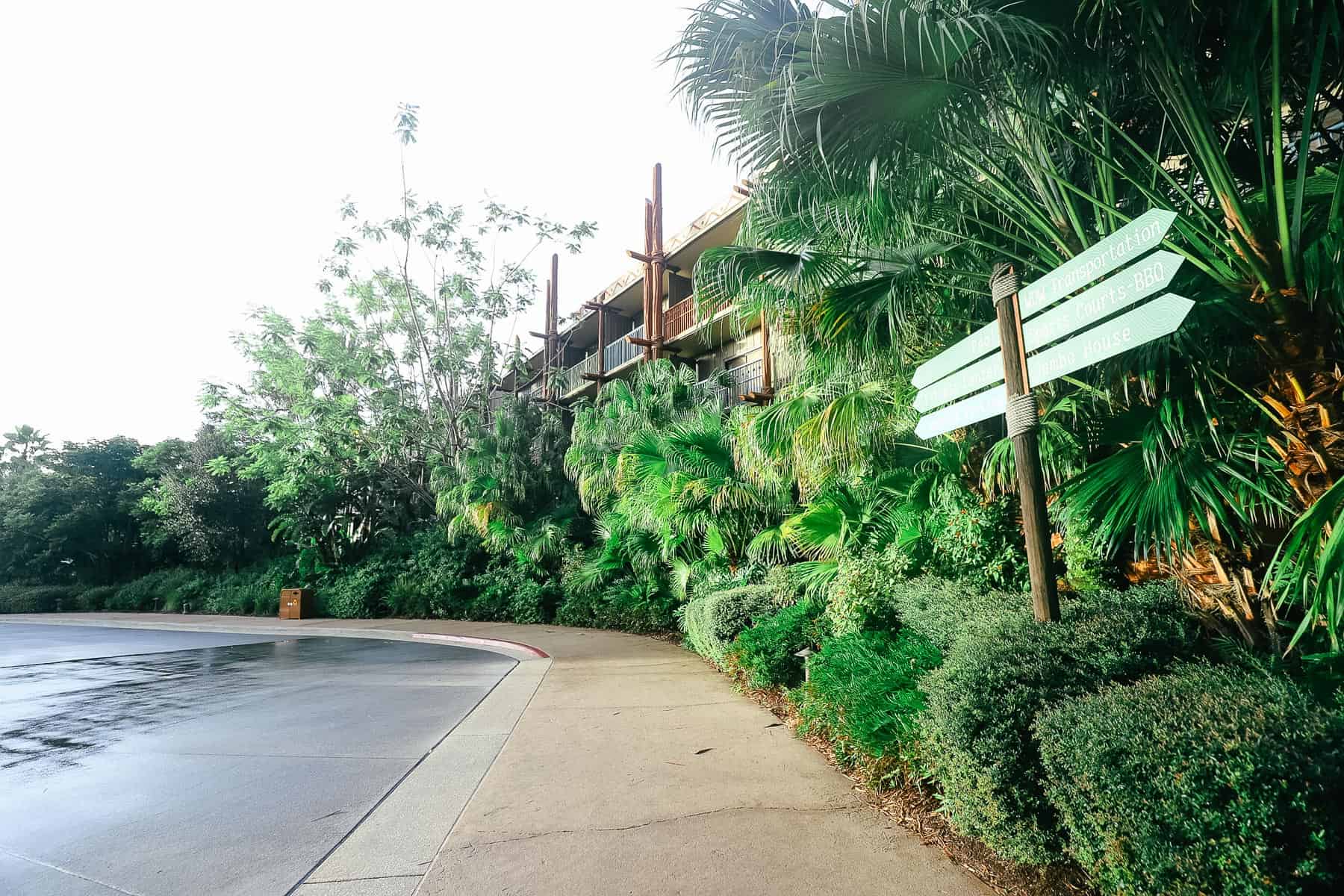 A sidewalk and a sign that points out the direction to Jambo House from Kidani Village. 