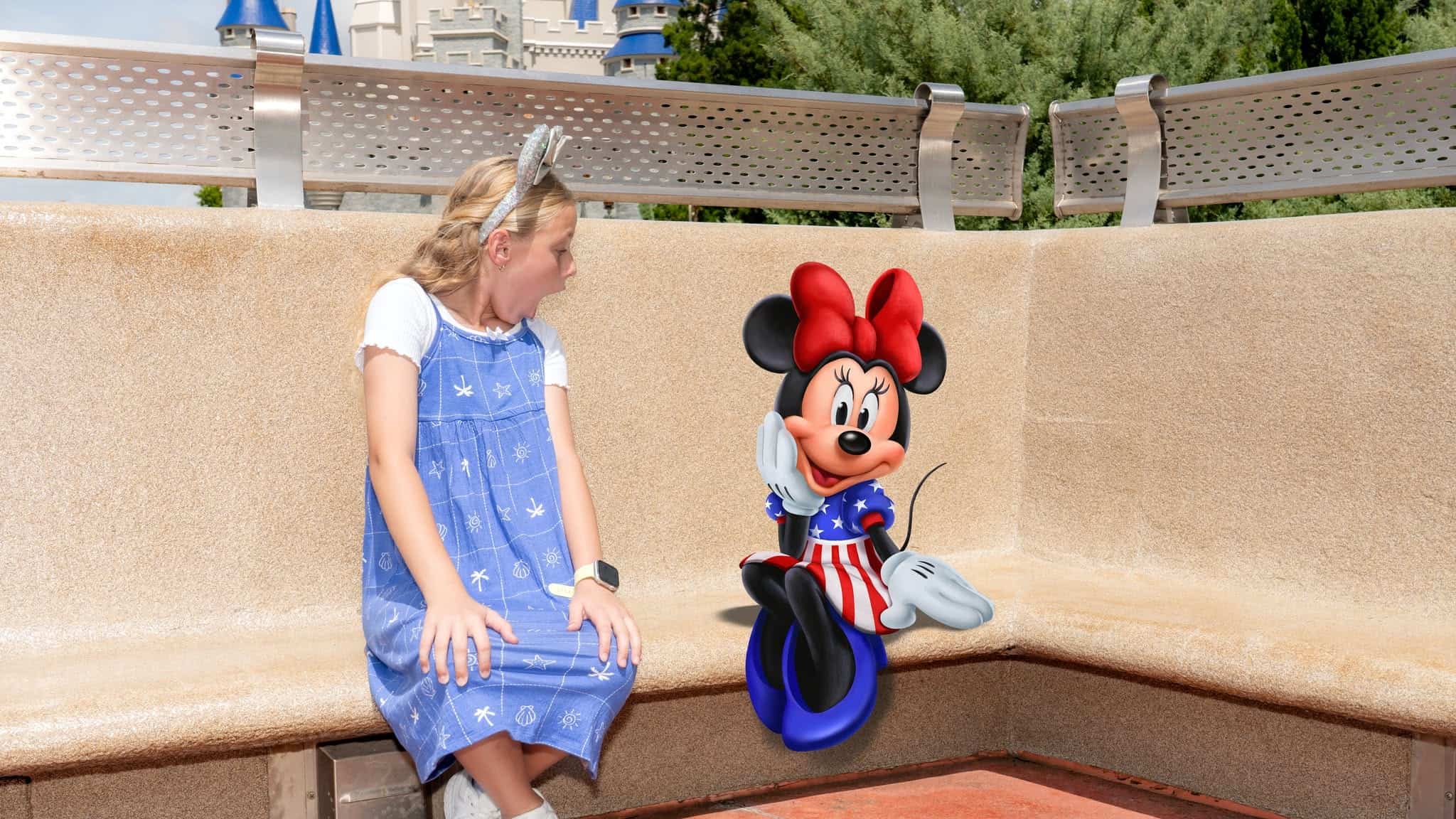 Minnie Mouse on a park bench wearing a 4th of July dress with red bow