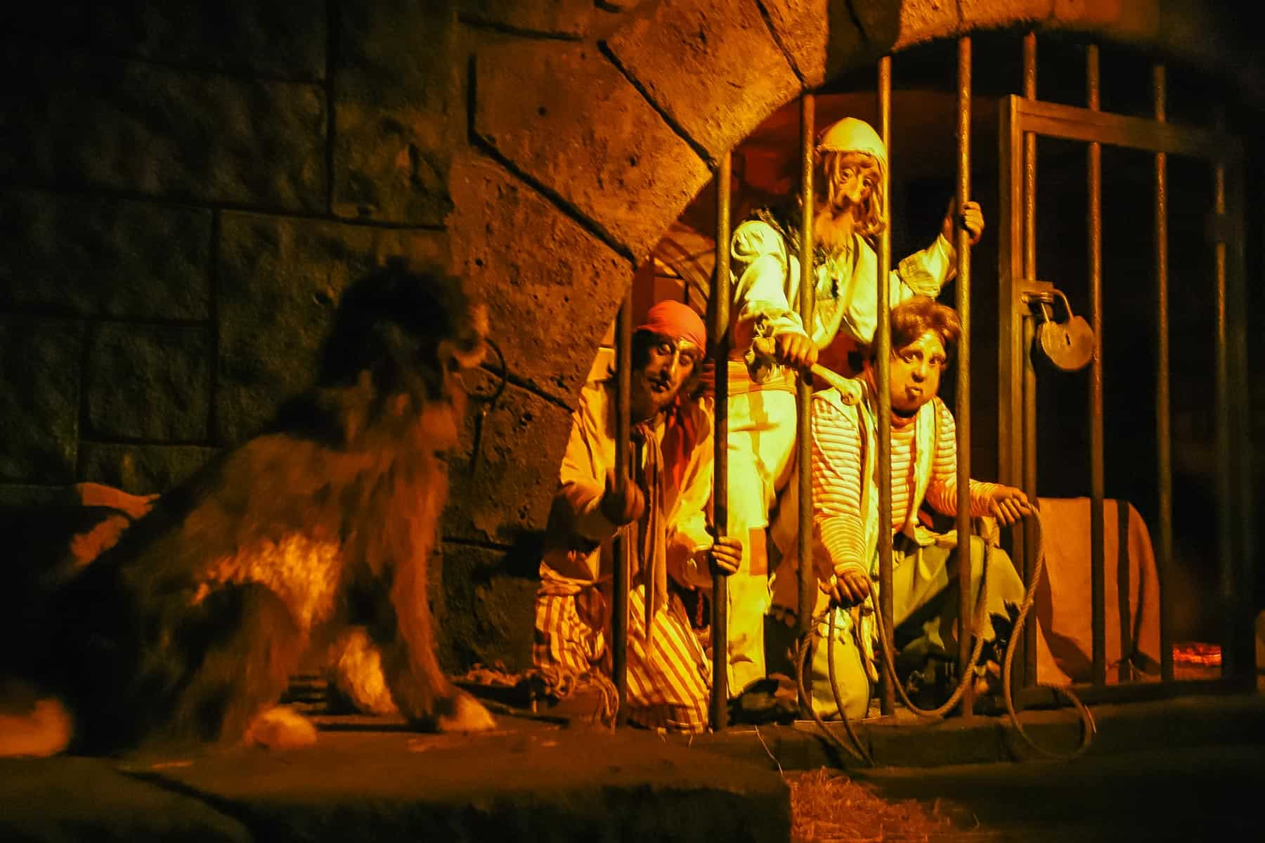 Jailed pirates throwing the dog a bone. The dog has a set of keys in his mouth. 