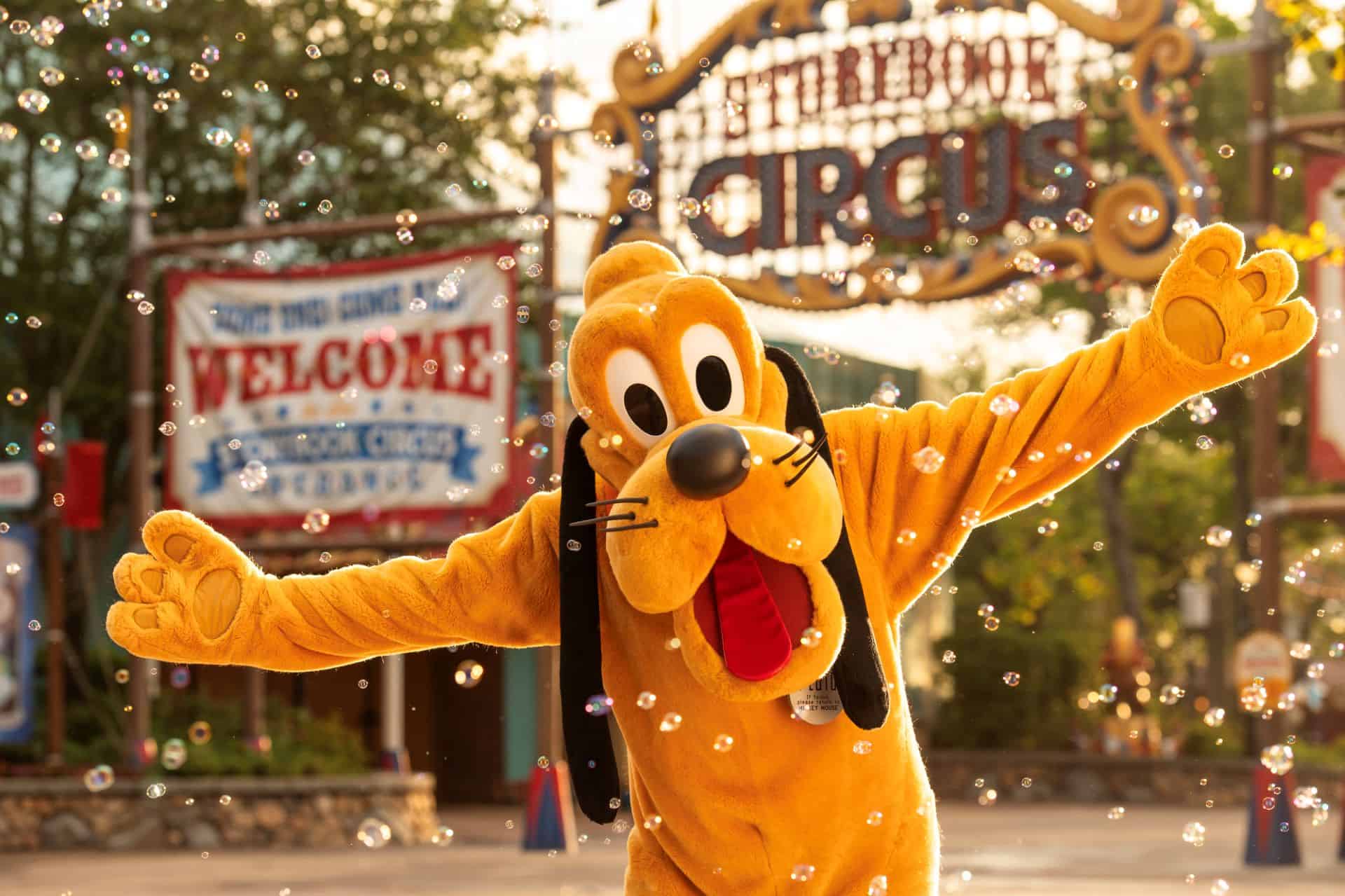 Pluto in front of the Storybook Circus sign for Cool Kid Summer at Magic Kingdom