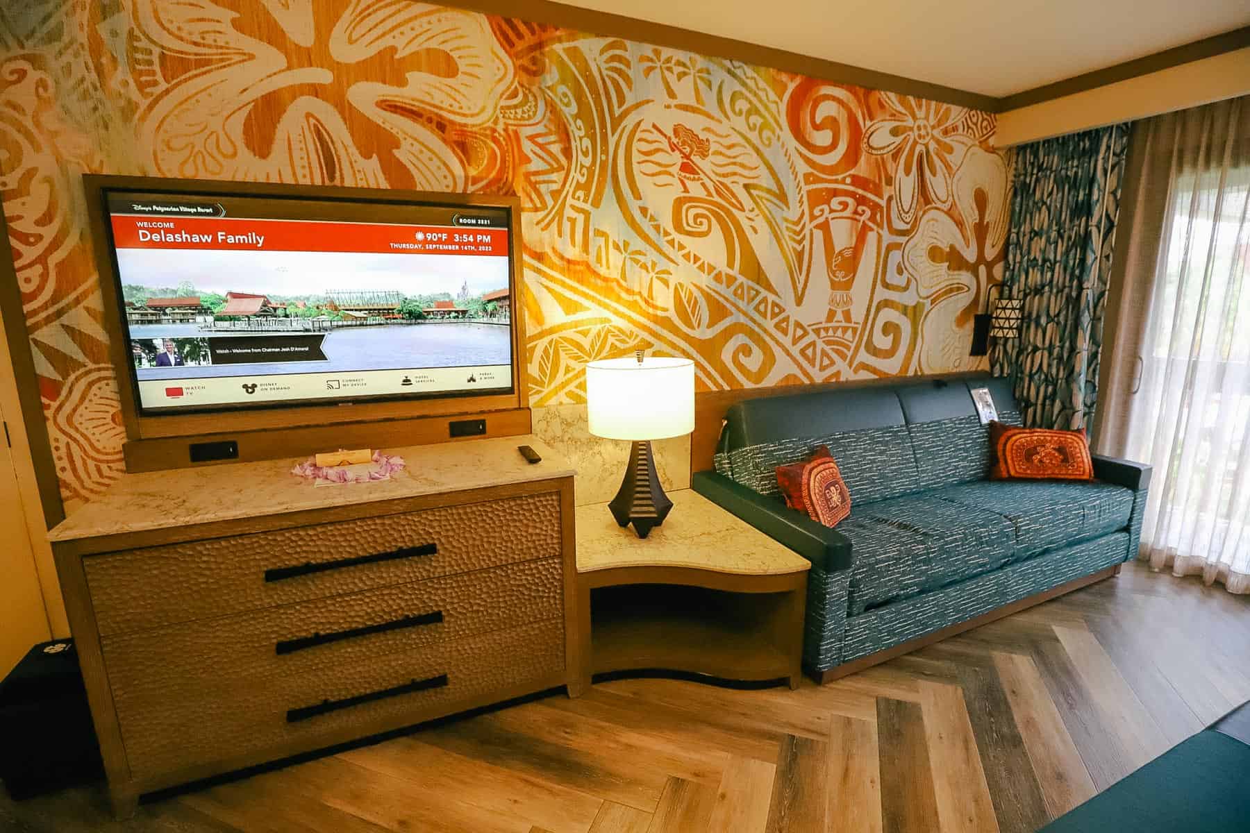 dresser, flatscreen television, and nightstand next to sofa bed