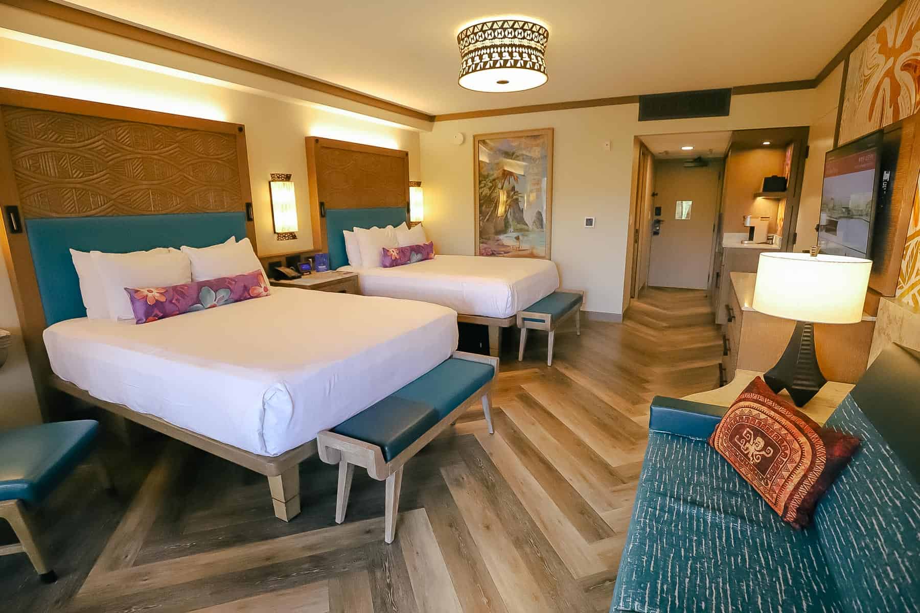 the Moana-themed room with two queen beds, a turquoise sofa that folds to make a single bed, and solid surface flooring