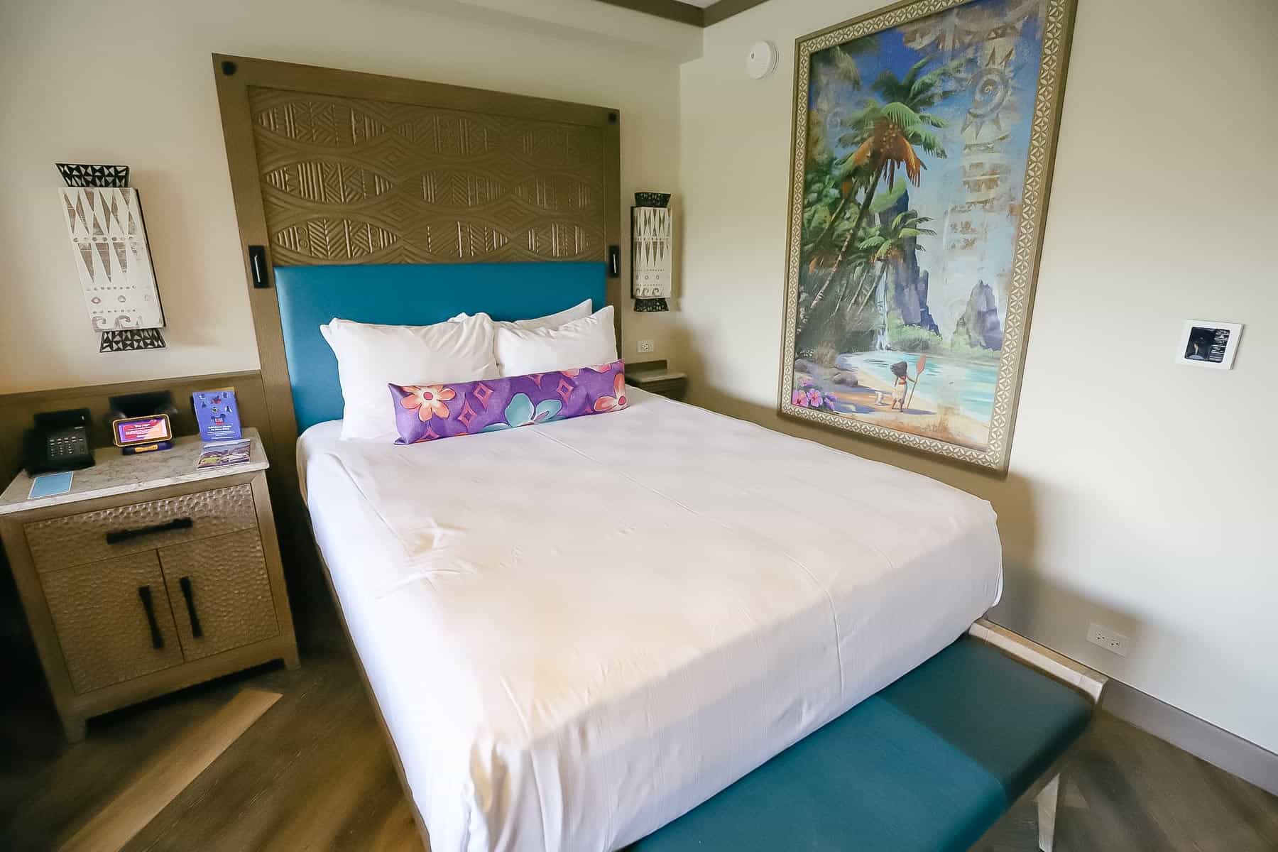 bed on the right side with artwork on the wall 