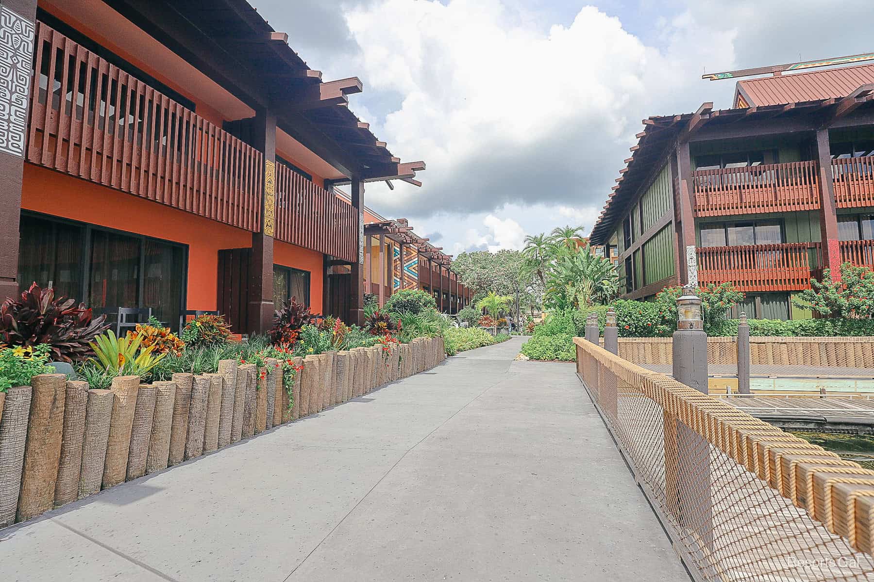 a walkway with Tonga building on the left with the marina on the right