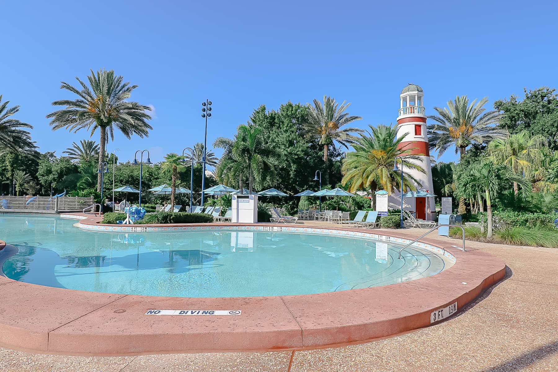 pool with red and white lighthouse in the background