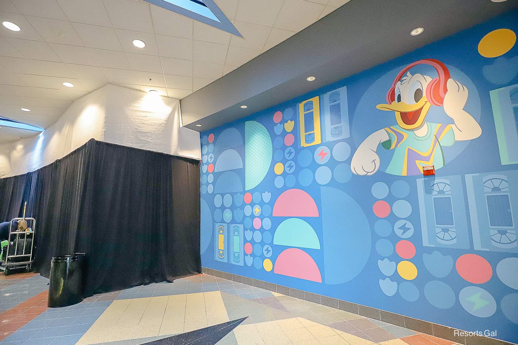 a blue feature wall with yellow and pink accents and Donald Duck 